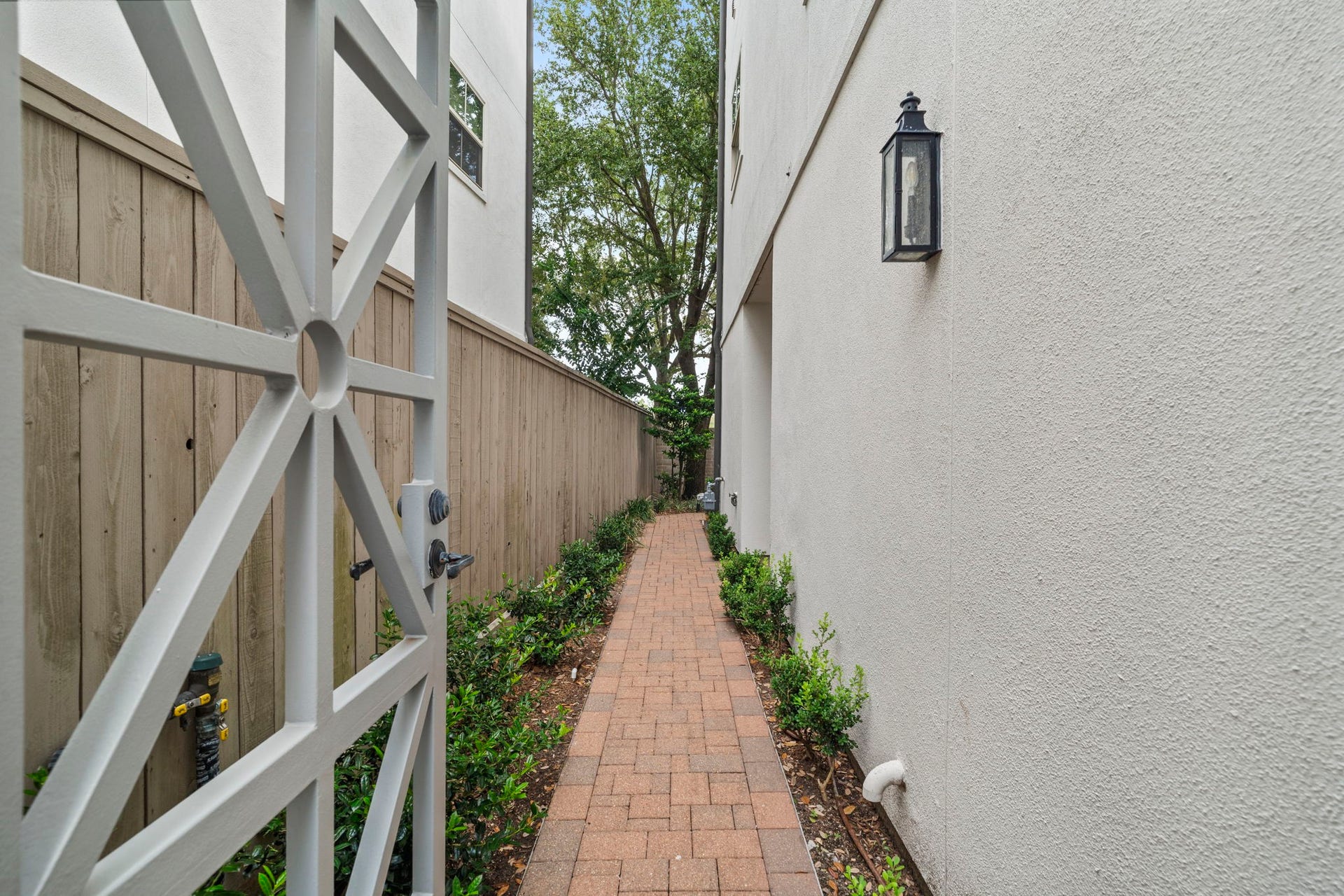 15931 Morgan Street, Sugar Land, TX 77478 A charming brick walkway along the side of the townhome leads to the homes private side entrance.