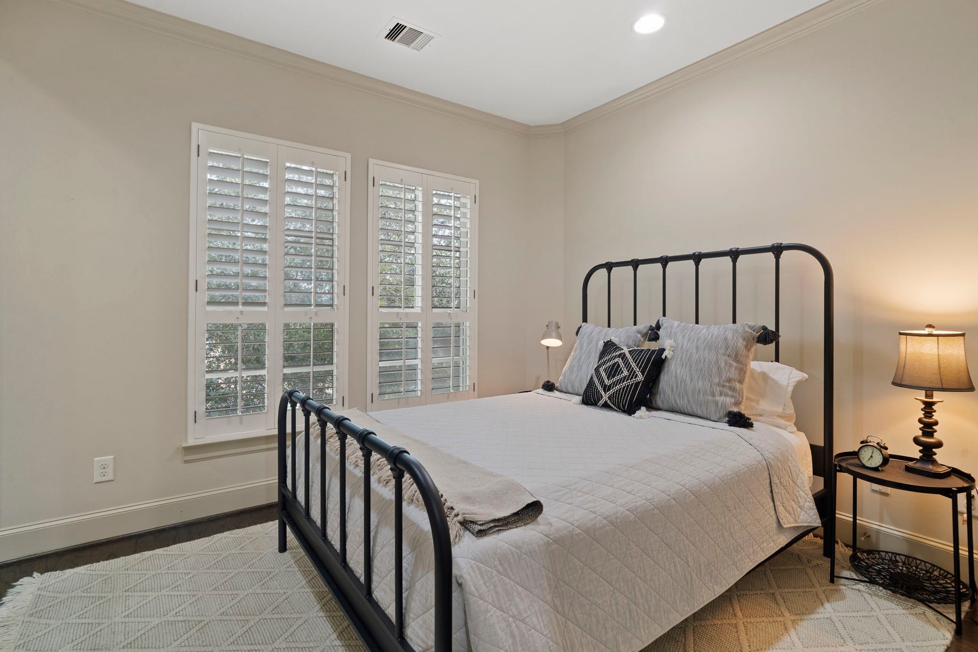 15931 Morgan Street, Sugar Land, TX 77478 Warm and inviting, this secondary bedroom features hardwood flooring, recessed lighting, and two large windows, along with a convenient full en suite bathroom.