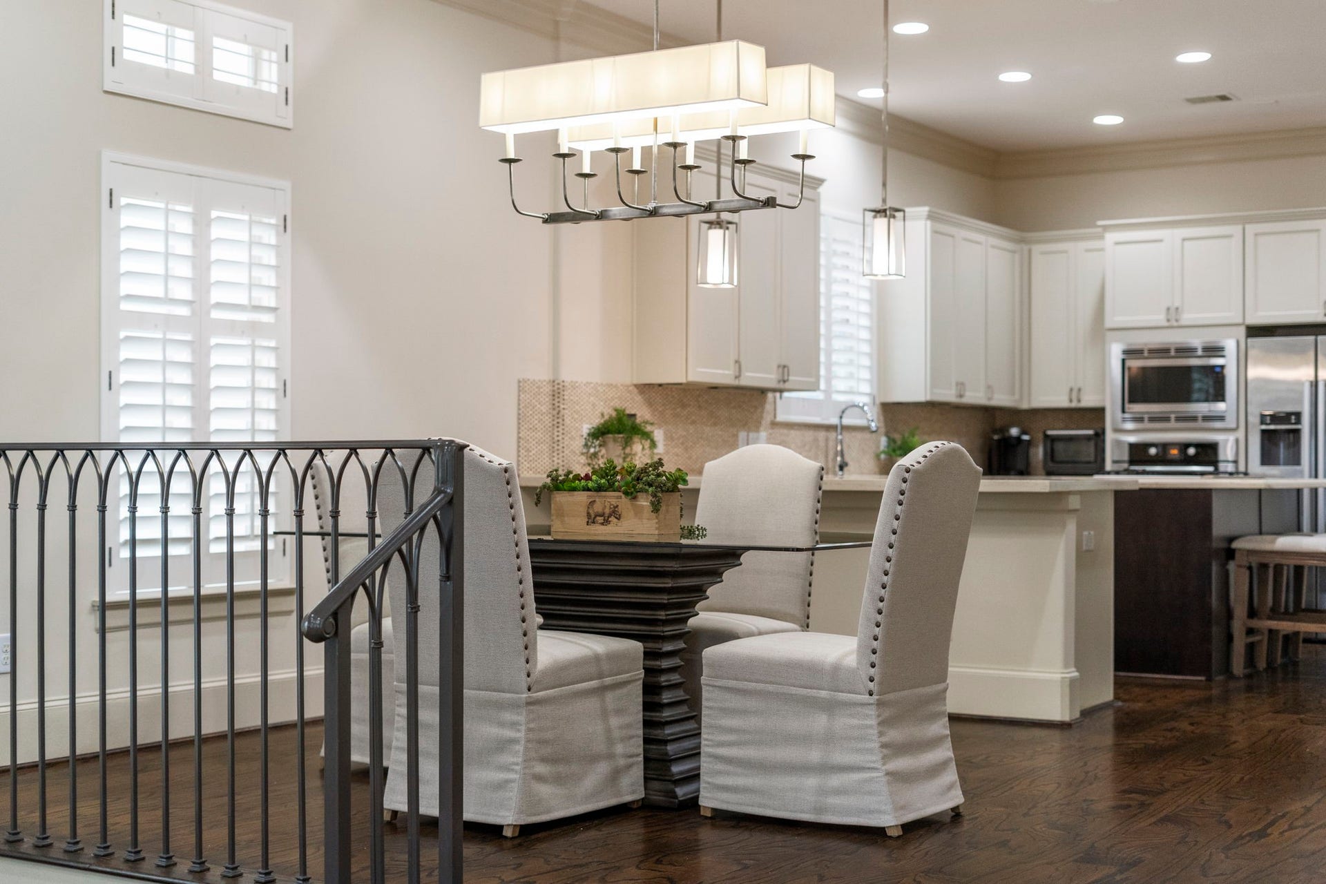 15931 Morgan Street, Sugar Land, TX 77478 Expansive windows fill the dining area with natural light, while rich wood floors and a striking chandelier add warmth and contemporary sophistication.