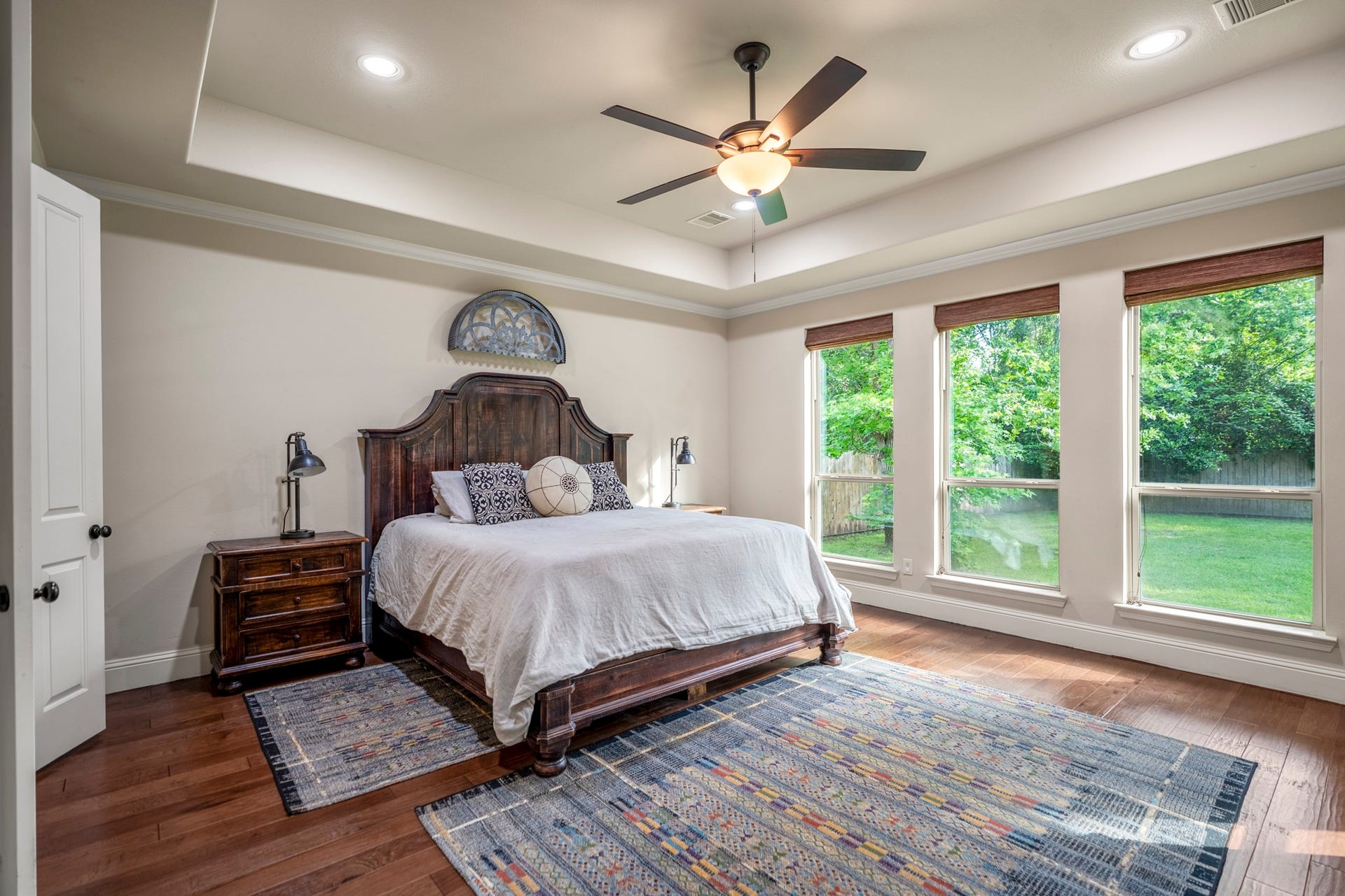The primary suite features a tray ceiling, recessed lighting and floor to ceiling windows.