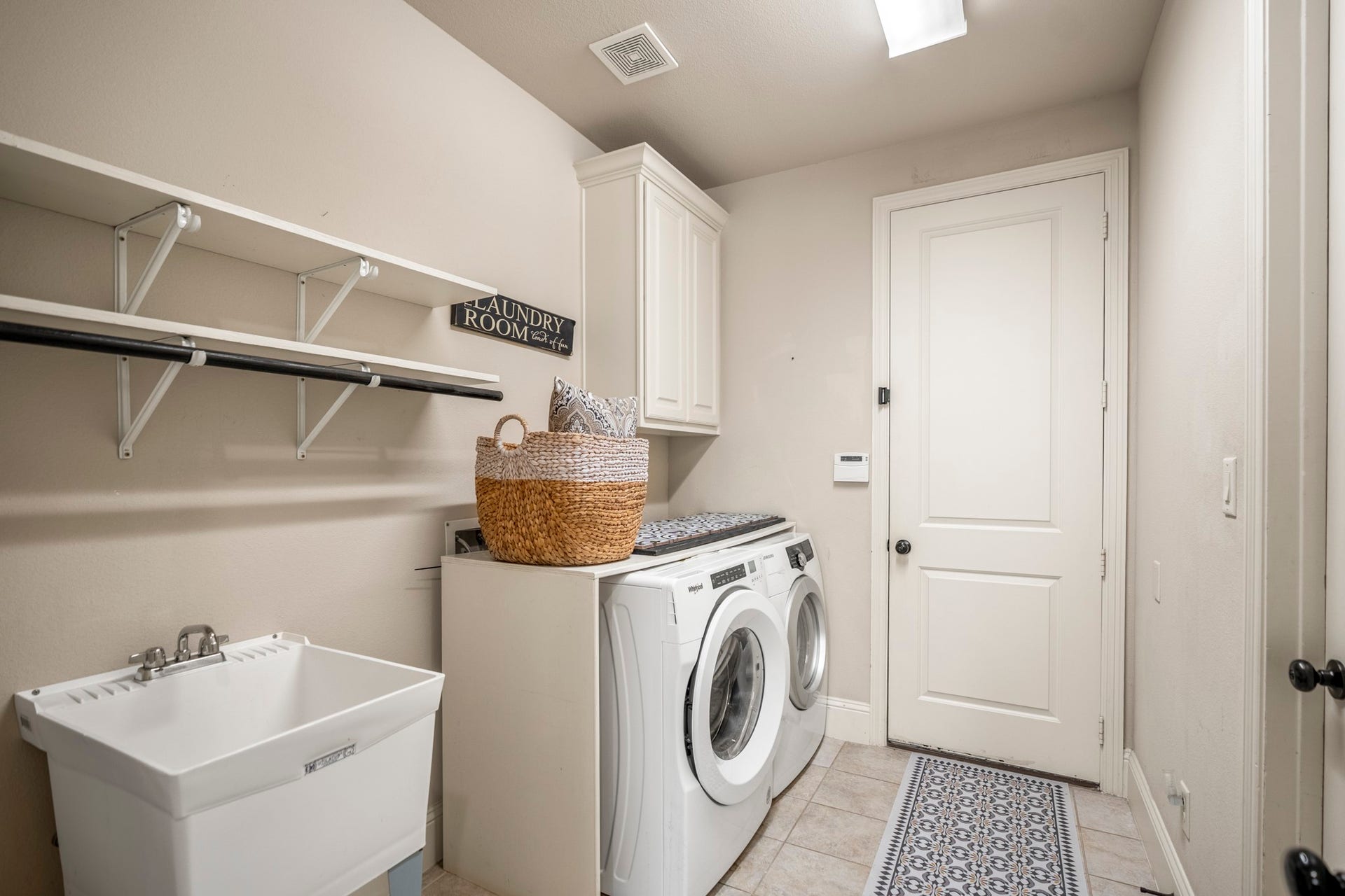 Who doesn't love a sink, shelves, hanging rack and cabinets in the laundry!