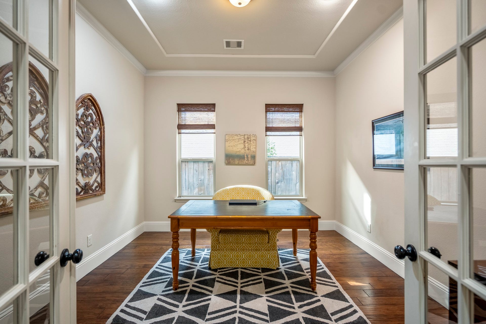 A private home office tucked behind elegant French doors is ideal for remote work, study, or a quiet creative space.