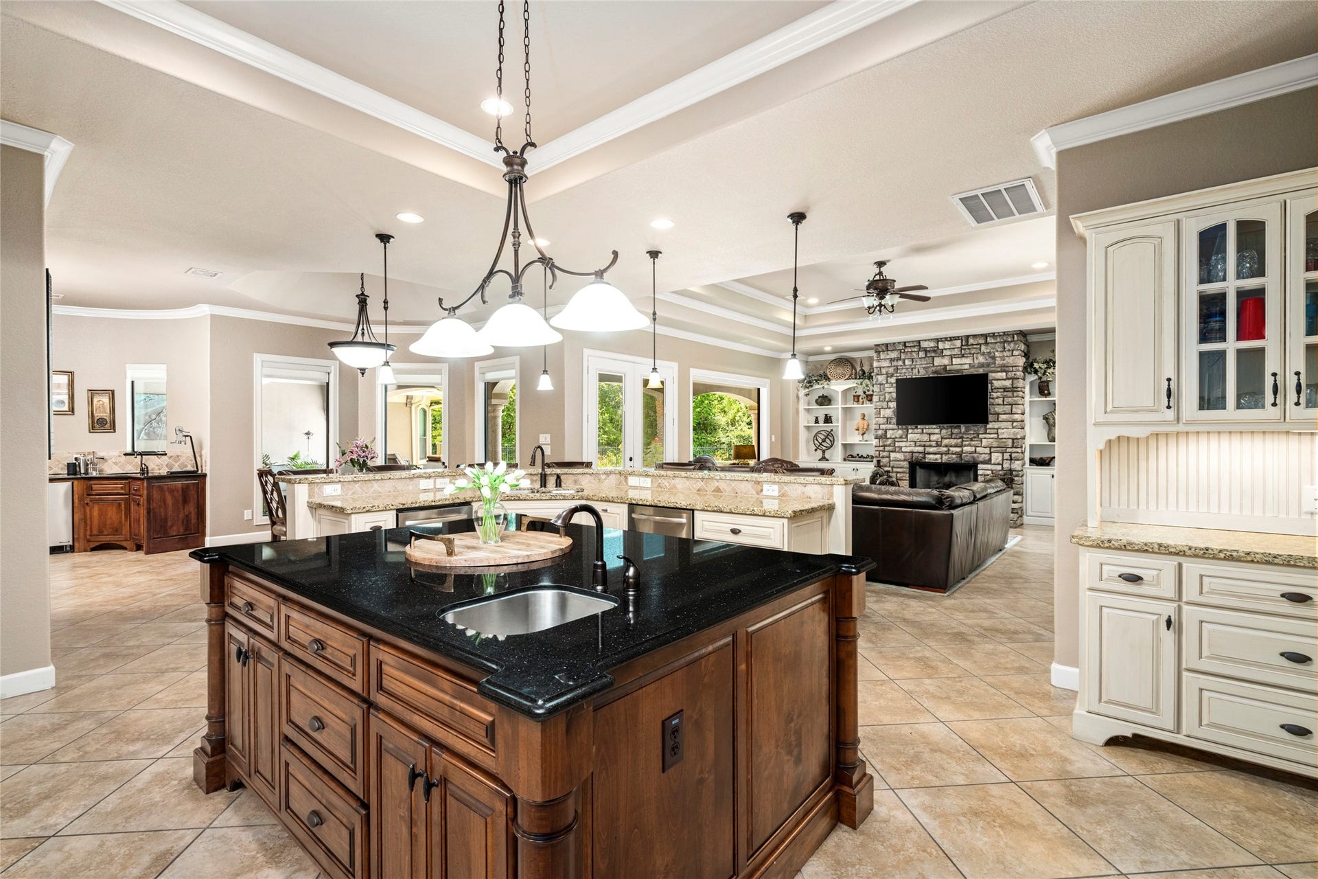 Another view of the kitchen overlooking the wet bar, breakfast nook, and family room, with a direct view of the outdoor retreat.