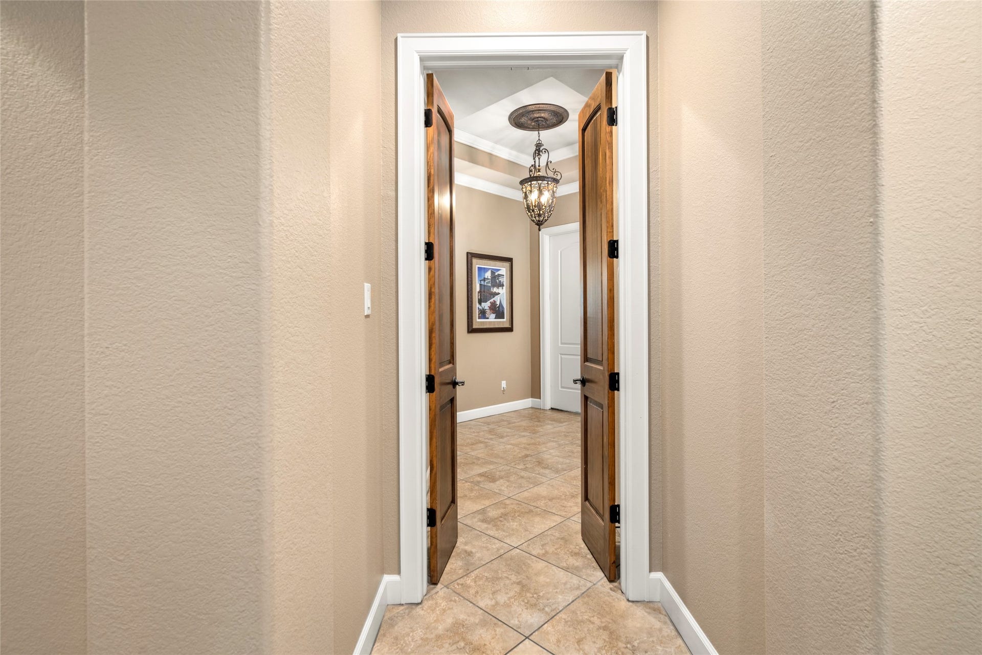 Custom wood doors open to the primary suite, a private wing of the home offering peaceful separation and refined entry.