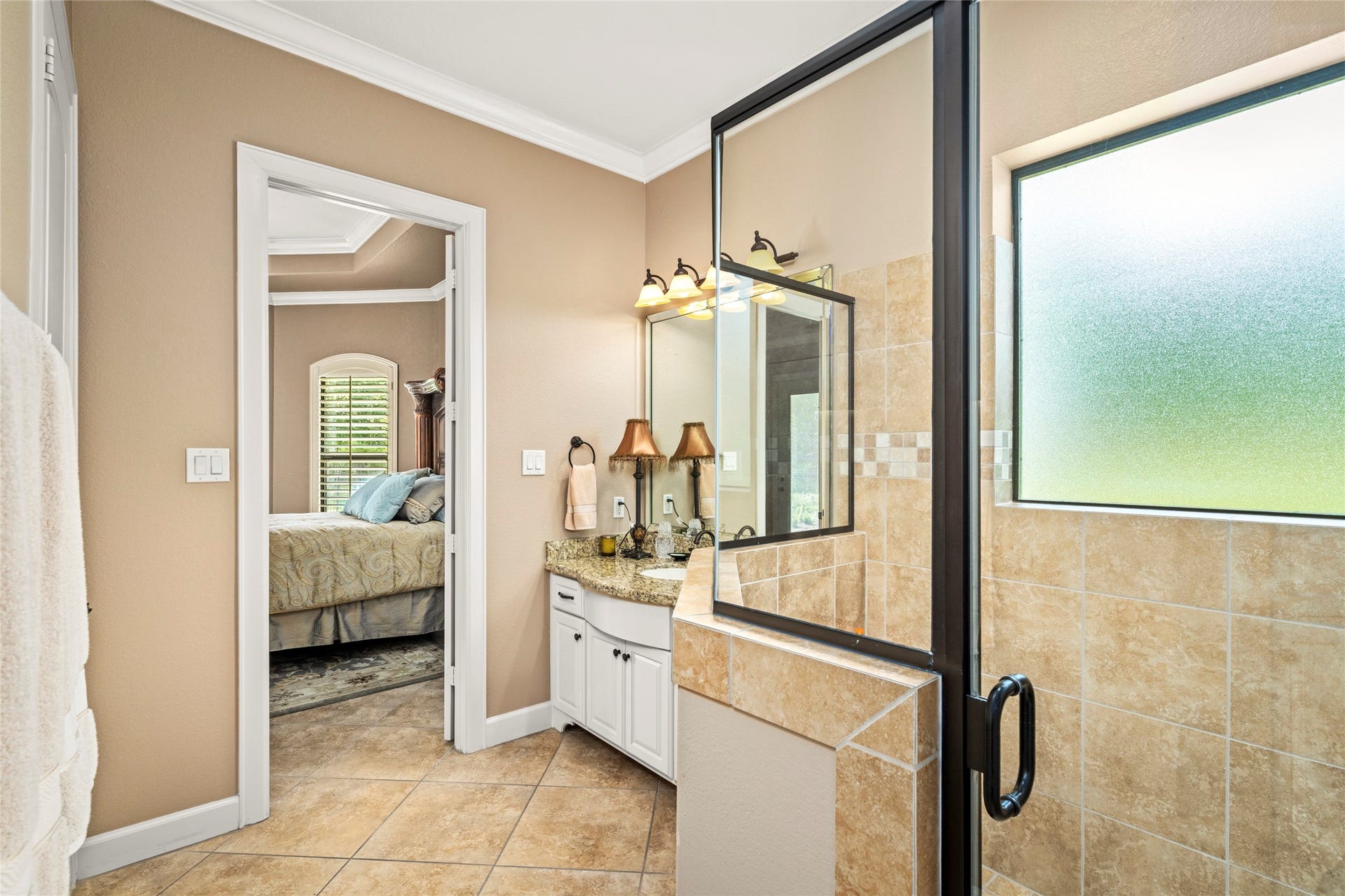 The en-suite bathroom offers a walk-in shower and granite countertops.