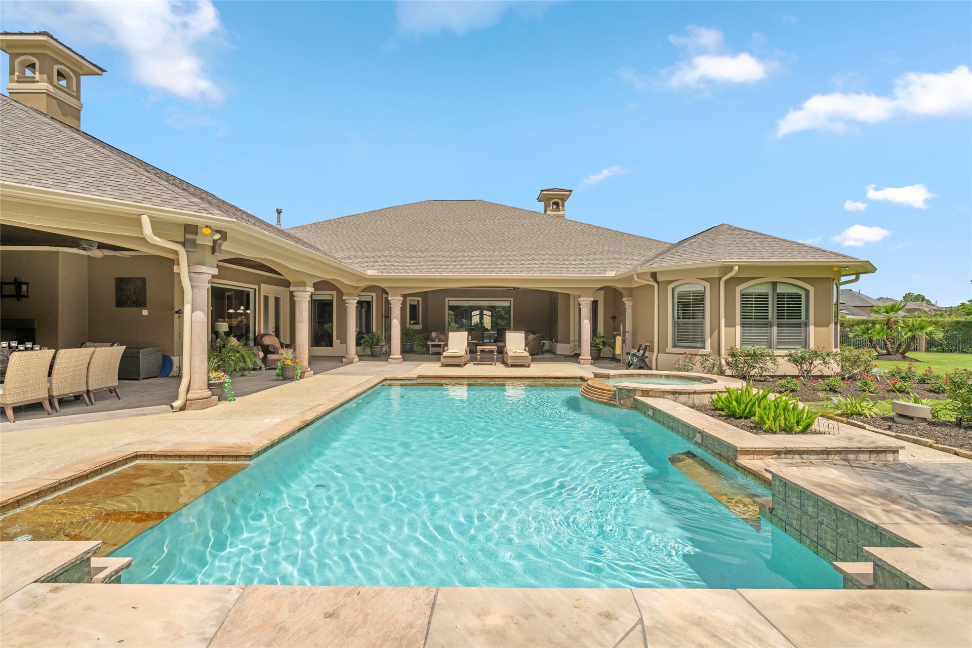 Back view of the home overlooking the pool and covered areas, so refreshing you will want to dive right in.