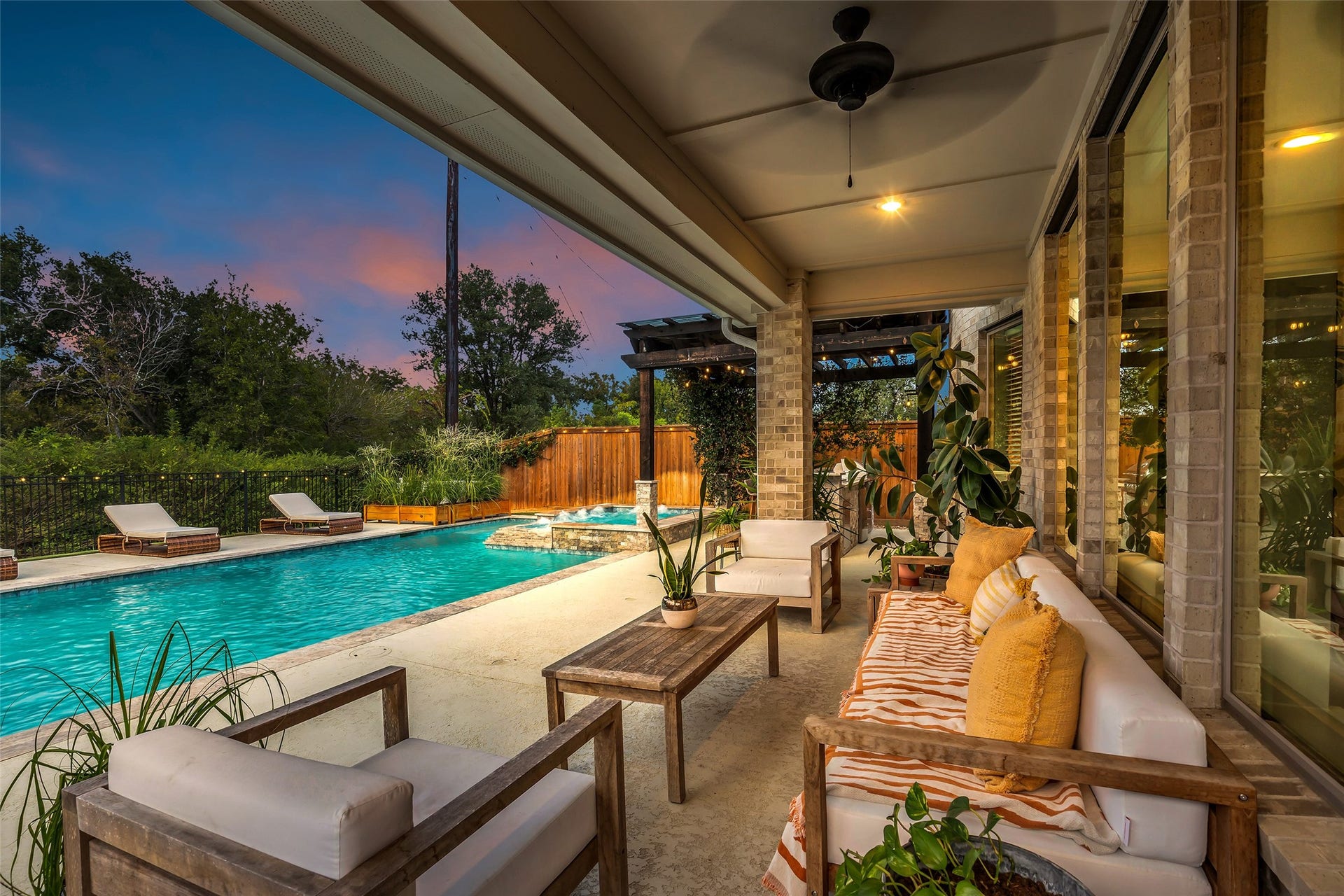 A tranquil covered patio overlooks the resort-style pool, creating an inviting outdoor retreat.