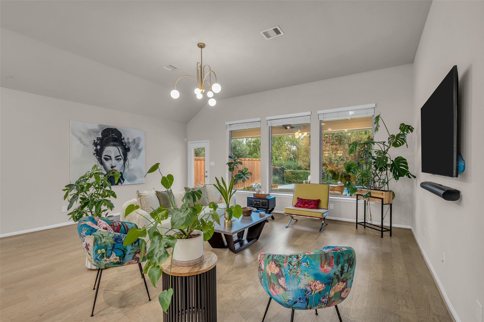 Expansive windows fill the spacious living room with natural light and backyard views.