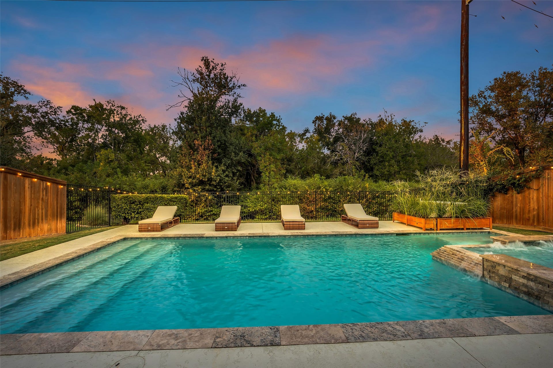 Resort-inspired pool with a spacious tanning ledge, elegant spa and lush surroundings.