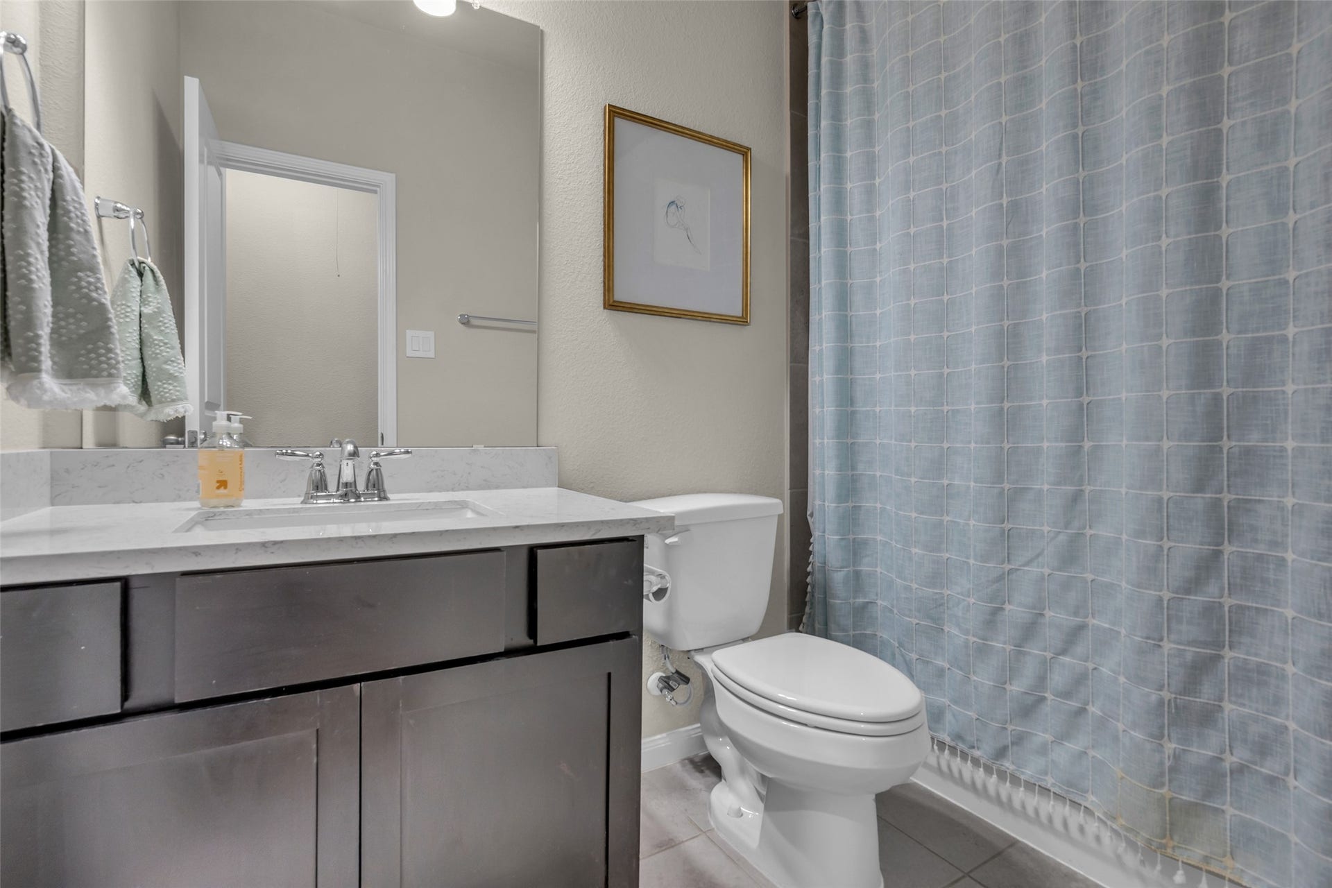 A bath with a dark-wood vanity, light countertop and tub/shower, convenient to the secondary bedrooms.