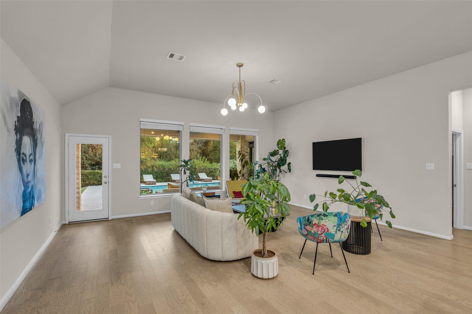 A glass door opens to the backyard, so gatherings flow easily from the sofa to the pool.