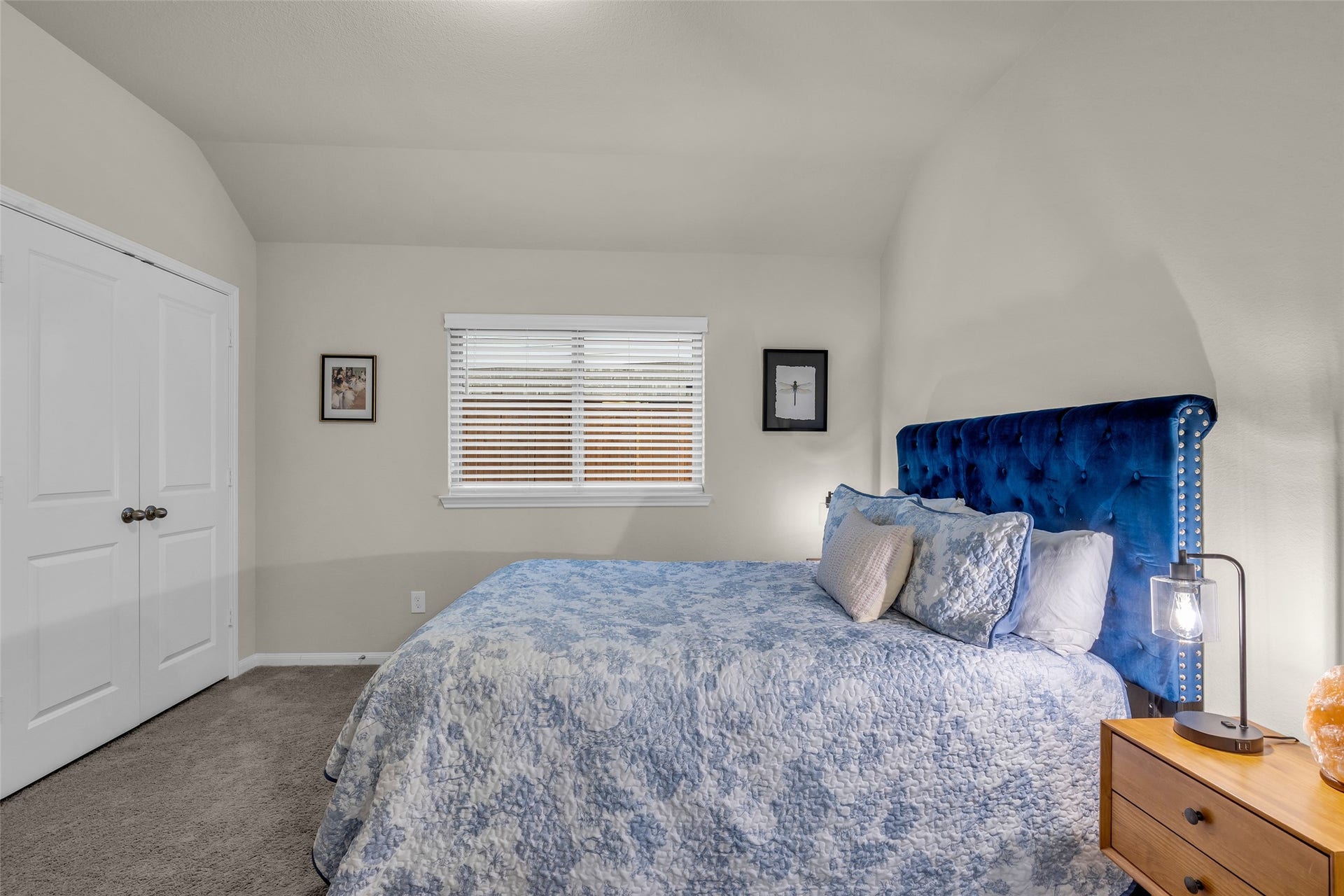 A secondary bedroom with a double-door closet and soft carpet, ready for guests.