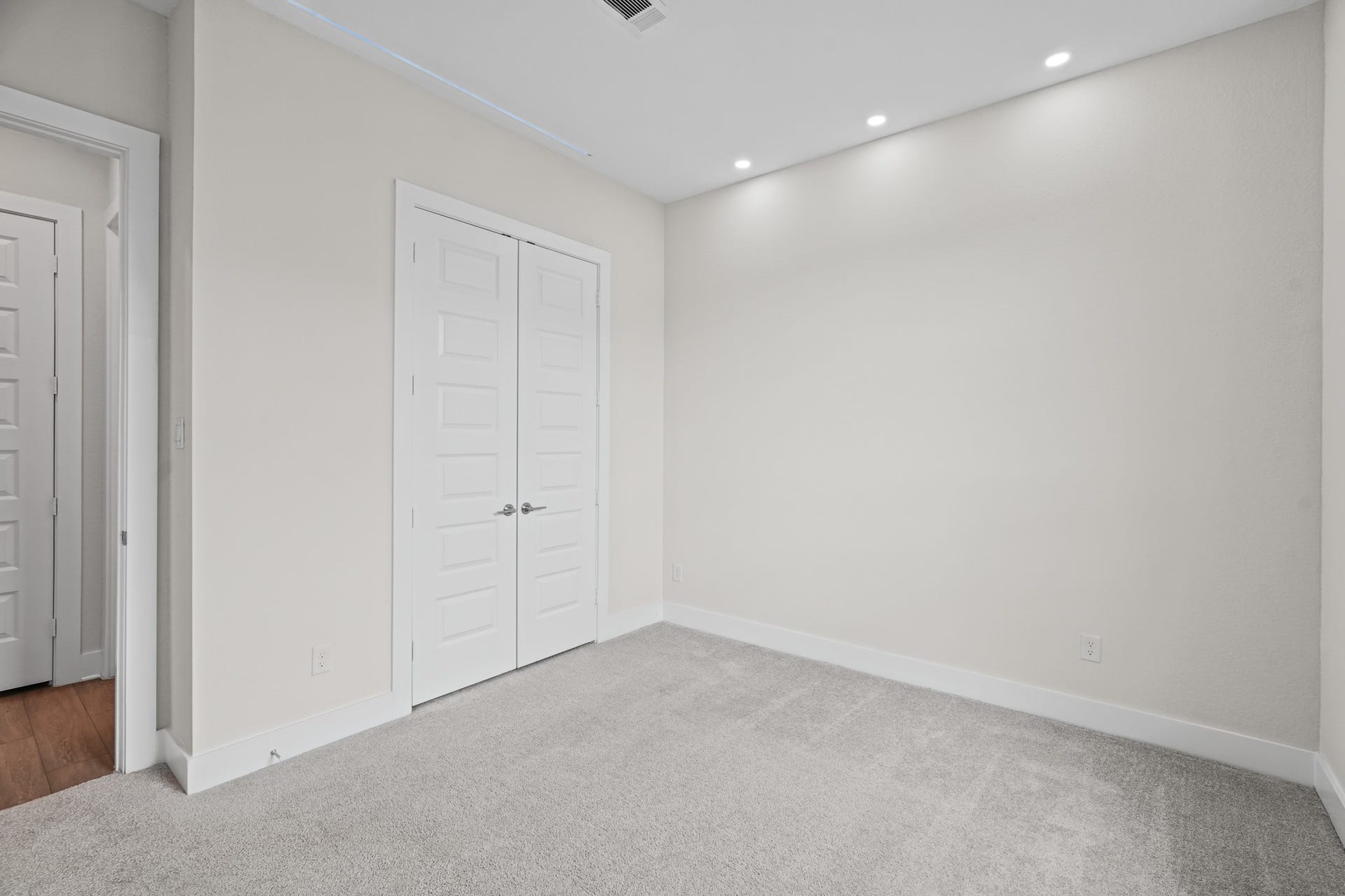 An additional bedroom offering closet storage, soft carpet underfoot and a quiet position down the hall from the home's main living, dining and entertaining areas.