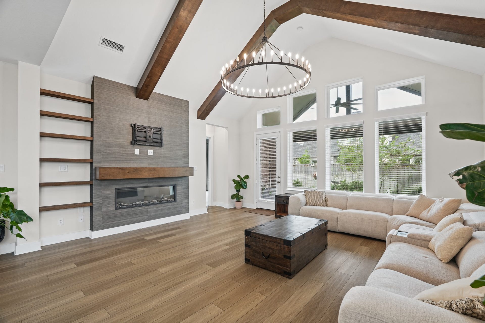 Comfortable living room with a wall of windows overlooking the backyard, a tiled fireplace surround and easy access to the covered patio for true indoor-outdoor living.