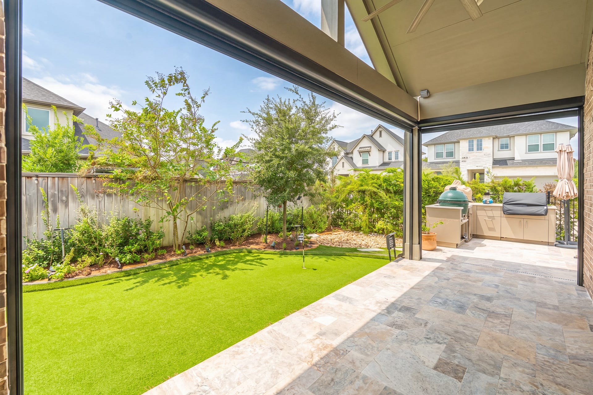 The covered patio looks out over a level, fenced backyard with established landscaping - shaded space for grilling, dining outdoors or simply unwinding after work.