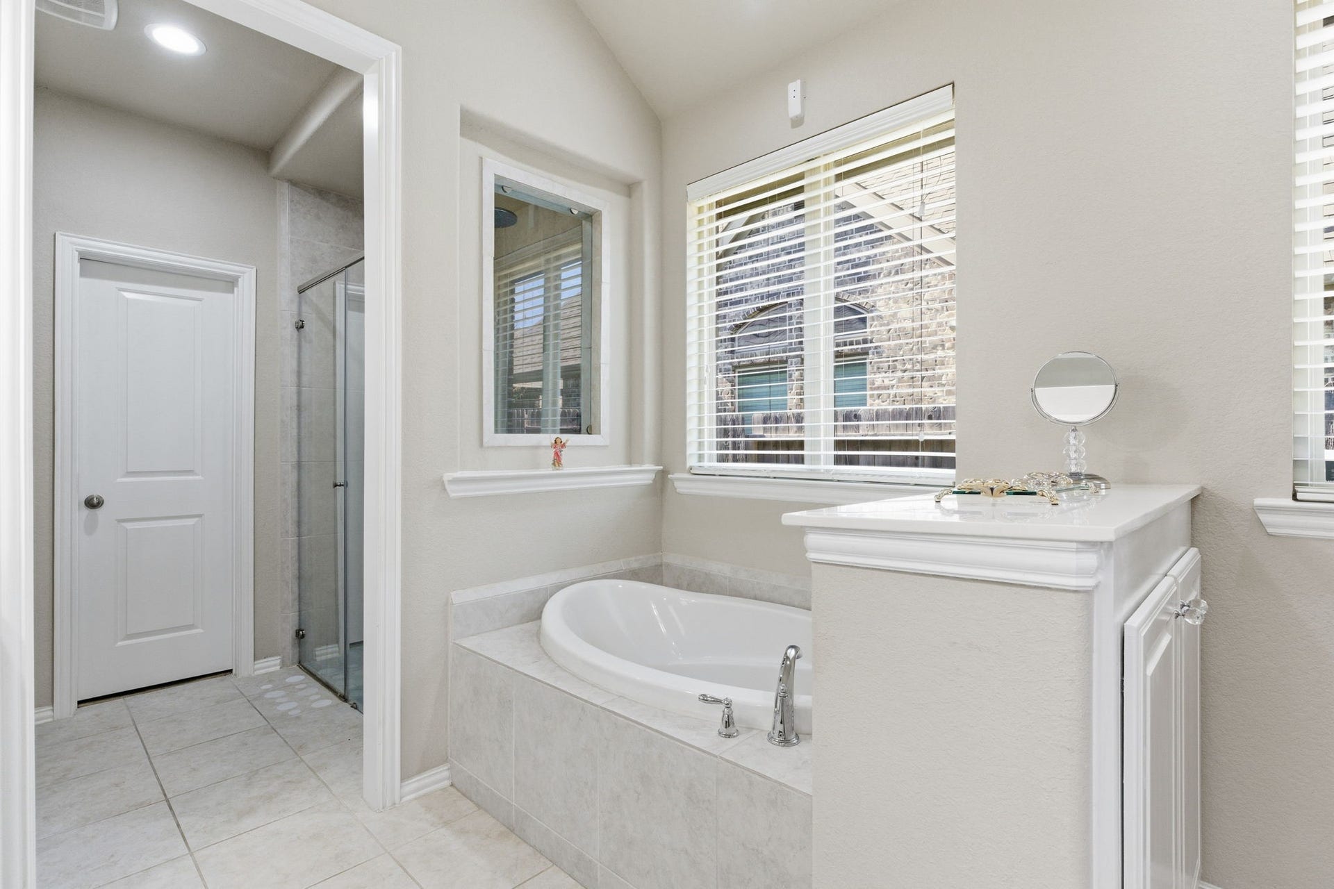 Separate jetted soaker tub for relaxation compliments the private walk-in shower.