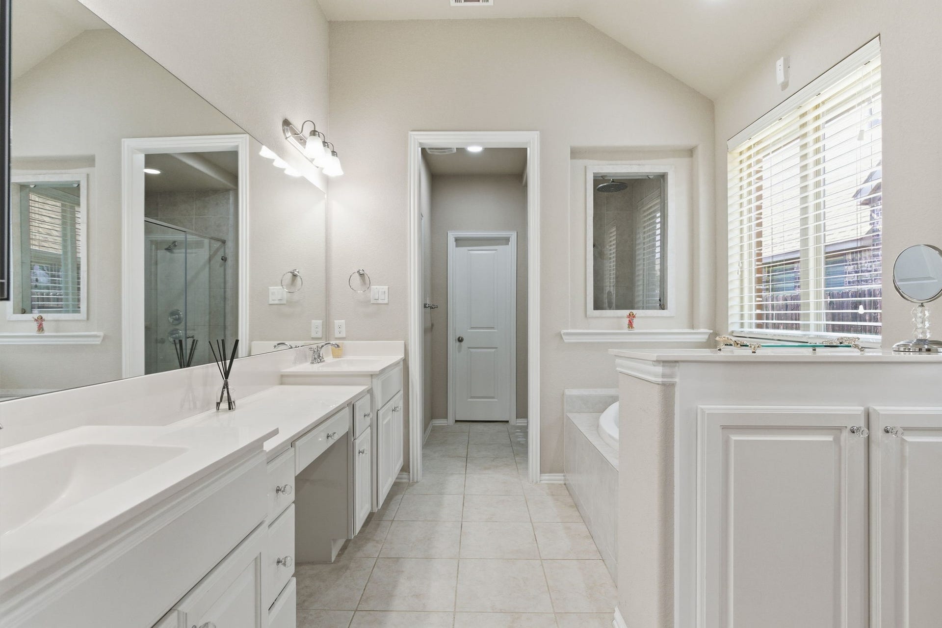 Ensuite primary bath boasts dual vanities, jetted soaker tub, walk-in shower, and large primary closet.