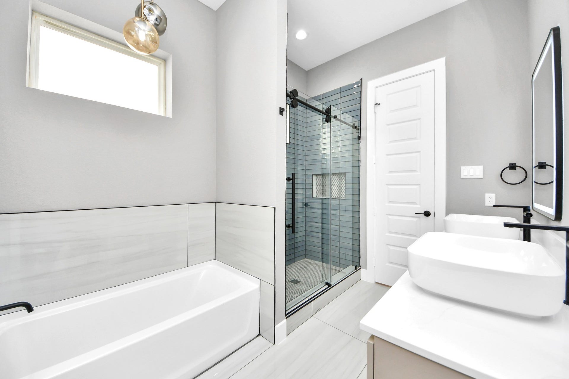 The primary bathroom delivers a serene modern setting with dual sinks, generous storage and elevated finishes.