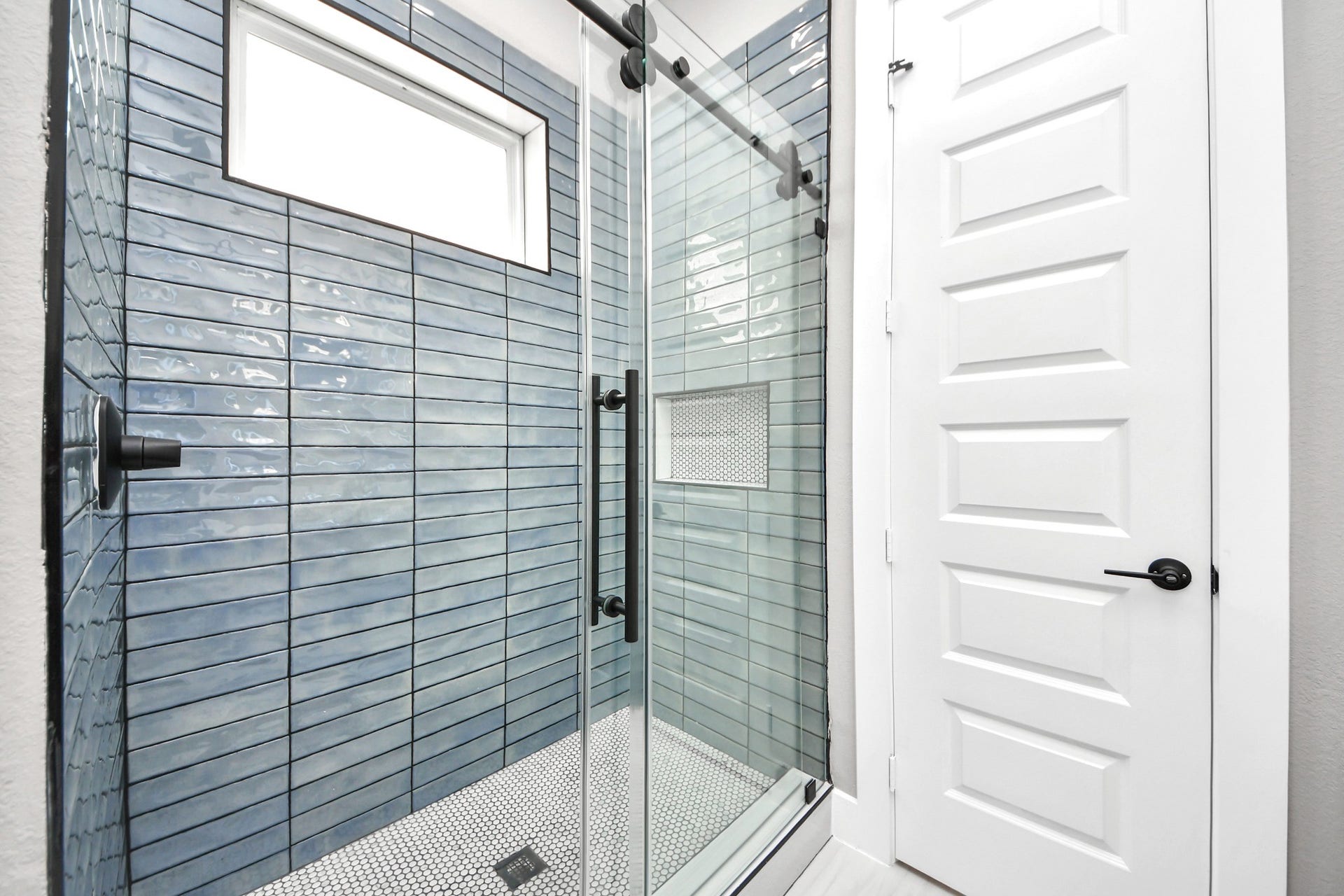 The oversized glass-enclosed walk-in shower adds a luxurious finishing touch to the primary suite.