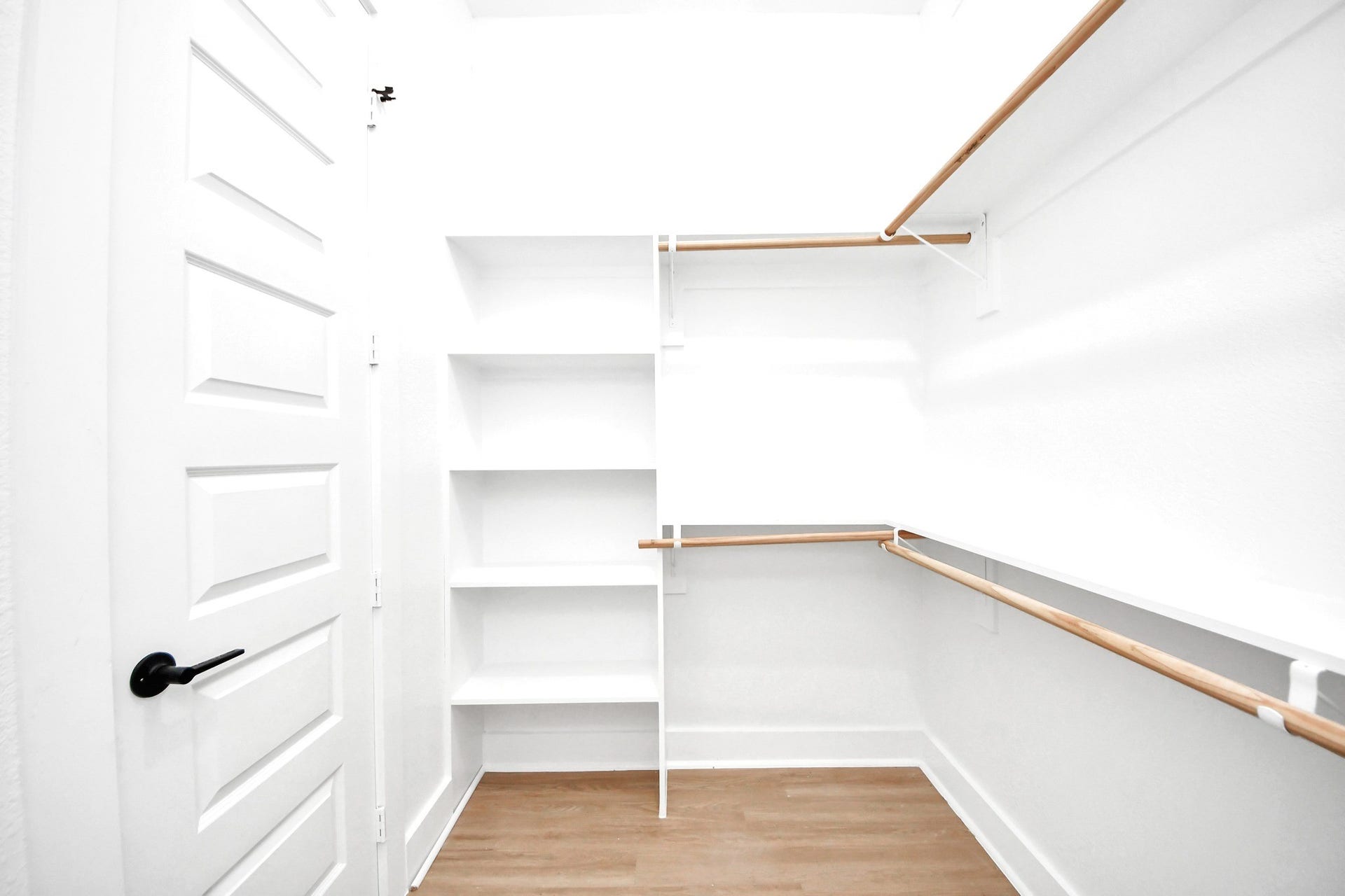 Built-in shelving transforms the primary walk-in closet into a practical, organized dressing space.