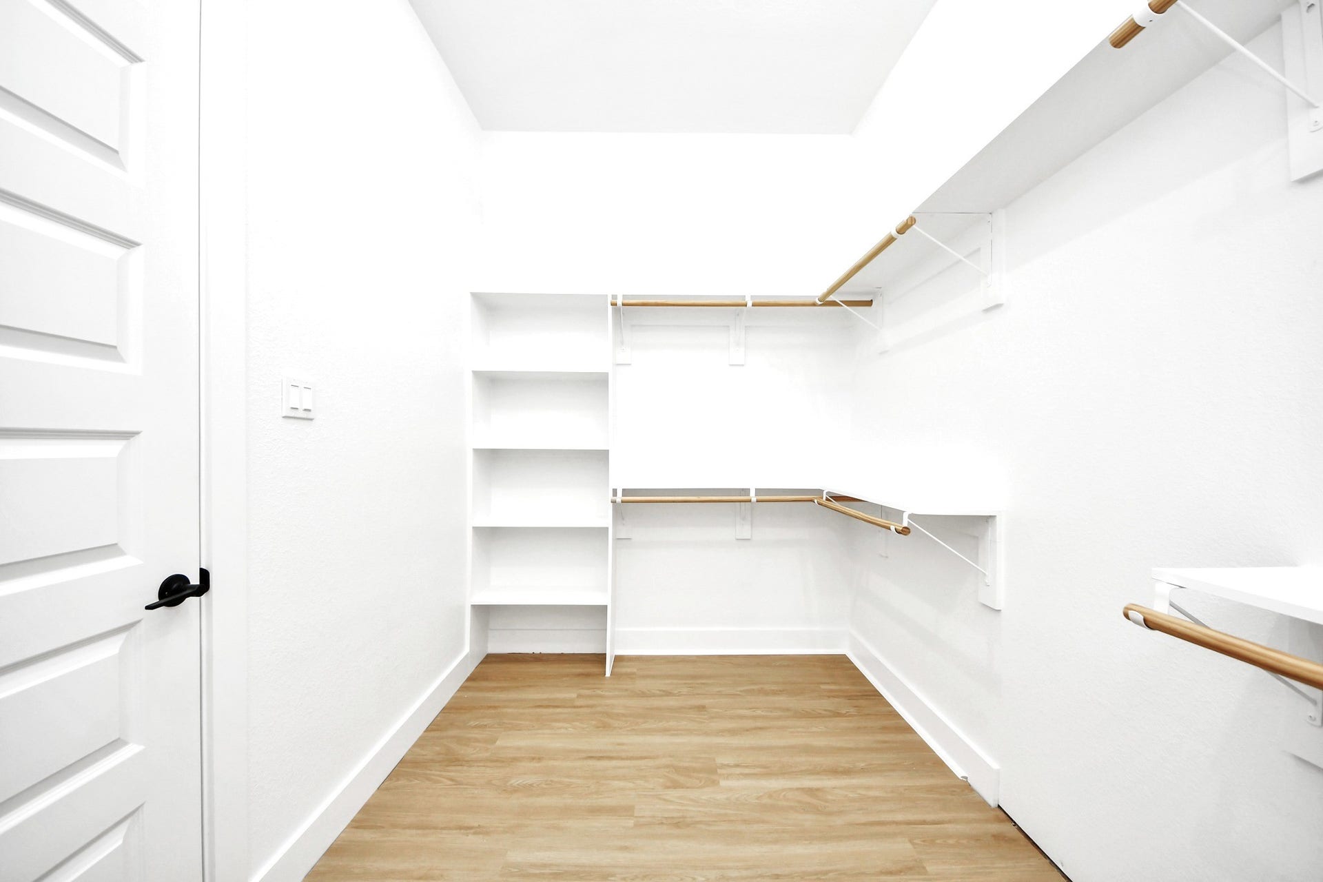 The oversized walk-in closet features extensive built-in shelving and room to keep everything beautifully organized.