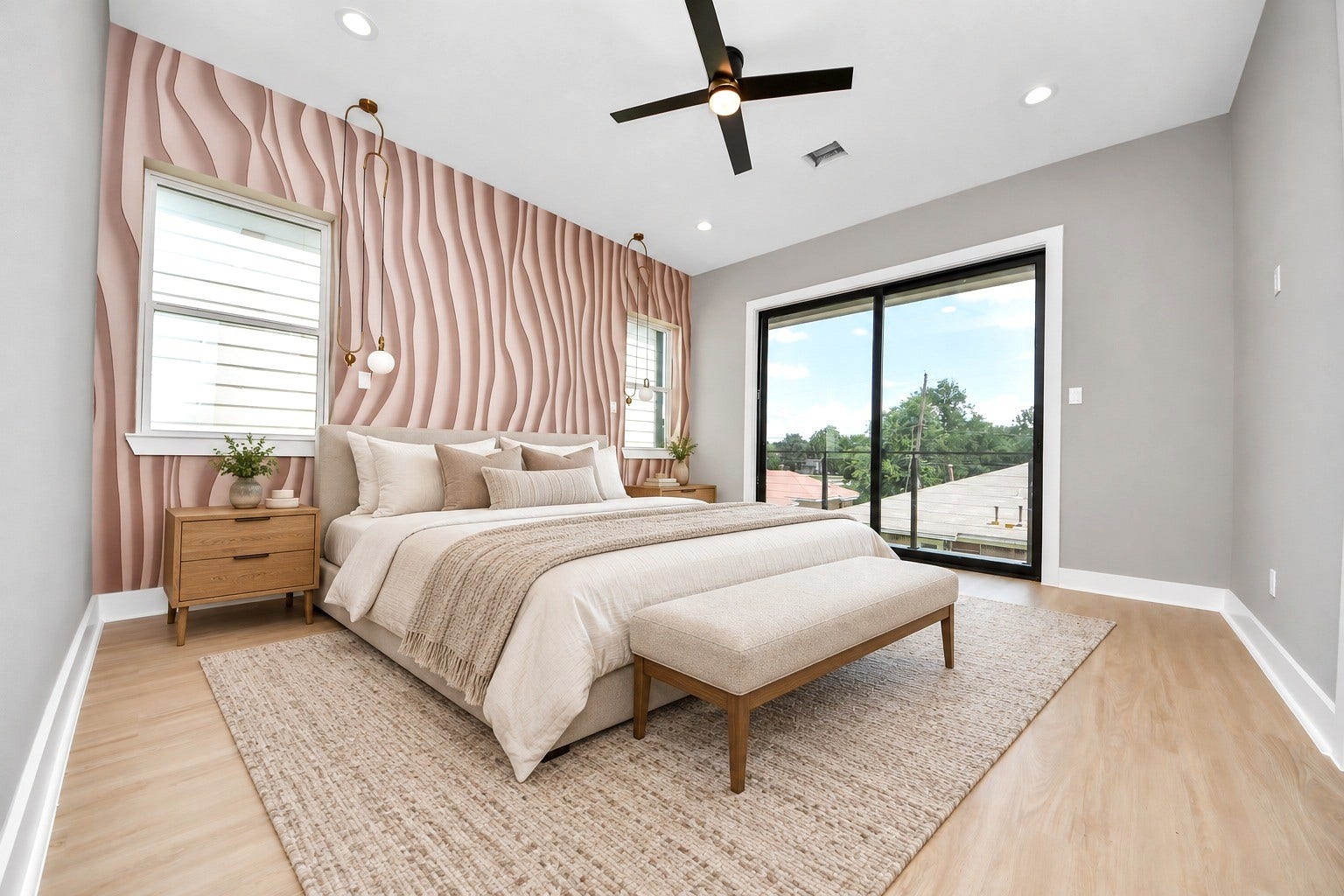 Unit Cs spacious primary retreat pairs a sculptural accent wall with direct balcony access.