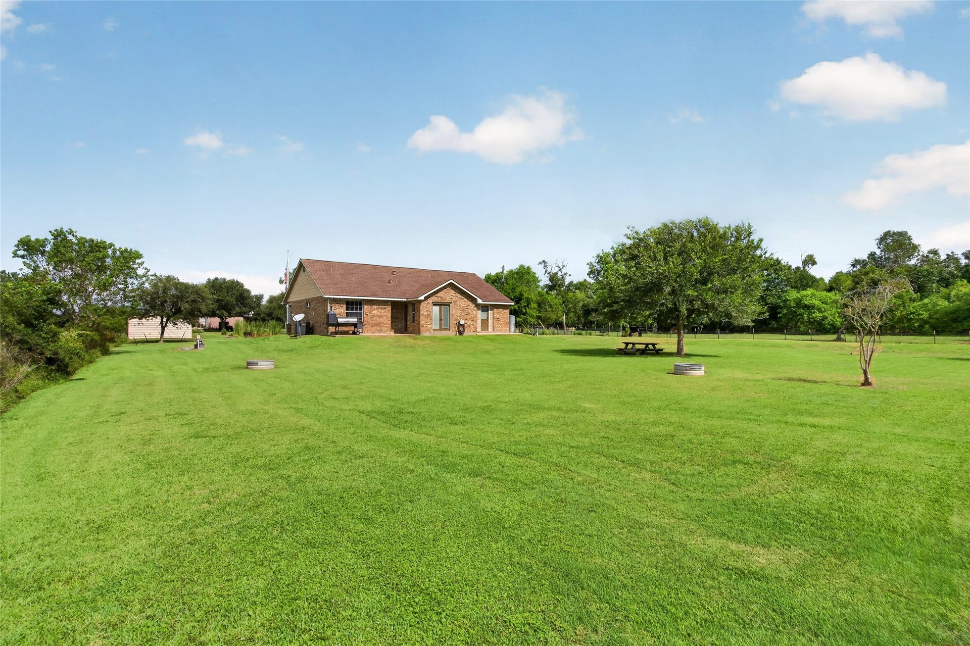 4933 1/2 Powers Ln, Alvin, TX 77511 Expansive backyard with wide-open green space, mature trees, and plenty of room to enjoy the outdoors.