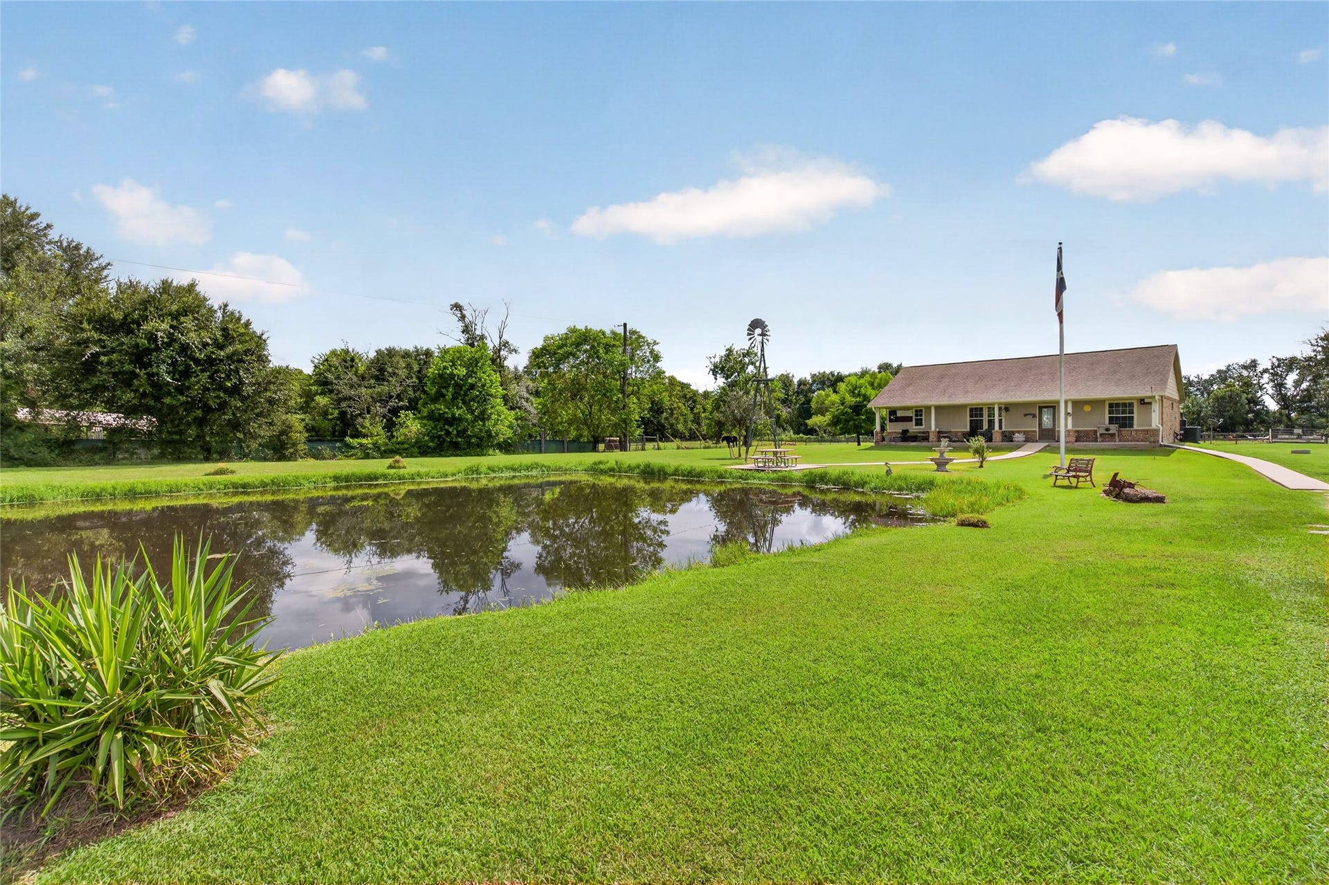 4933 1/2 Powers Ln, Alvin, TX 77511 Beautiful pond setting surrounded by mature trees, open green space, and tranquil country views.