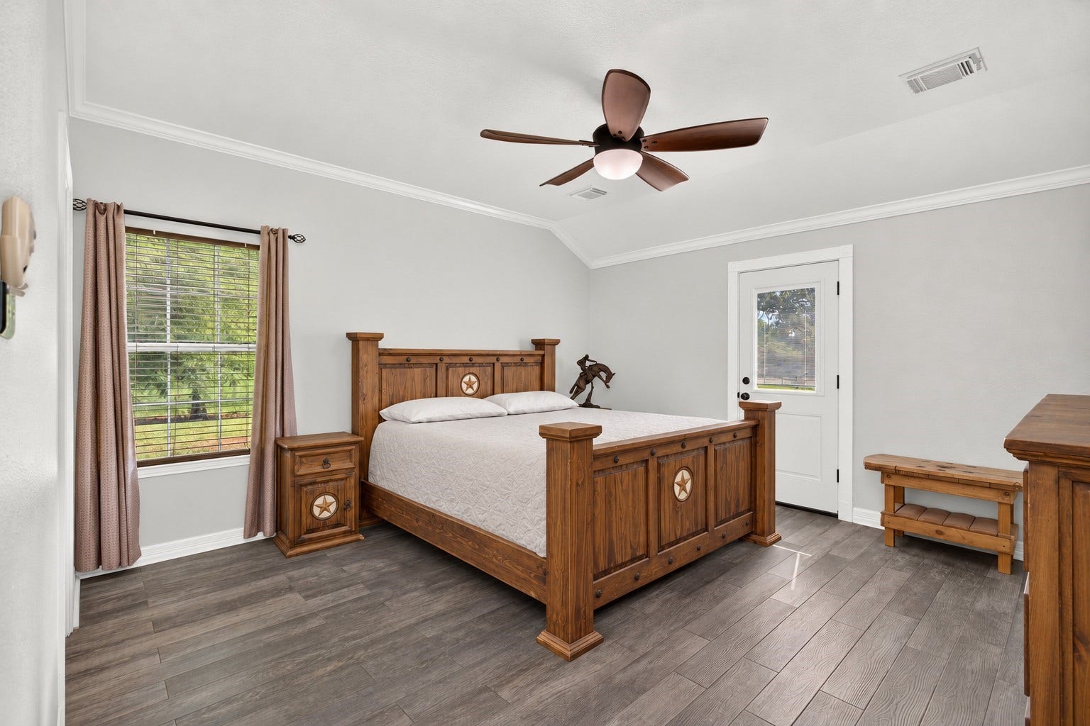 4933 1/2 Powers Ln, Alvin, TX 77511 Spacious primary bedroom with a high ceiling, crown molding, and wood-look tile flooring.