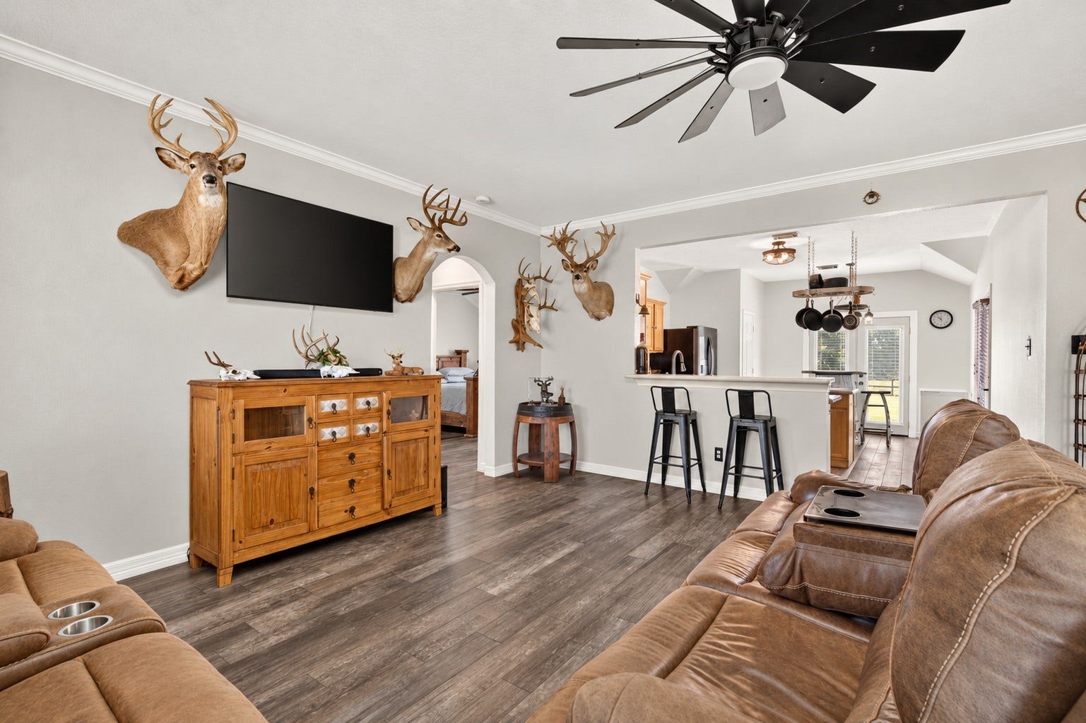 4933 1/2 Powers Ln, Alvin, TX 77511 Living room with crown molding, an oversized ceiling fan, and an open view into the kitchen and breakfast area.