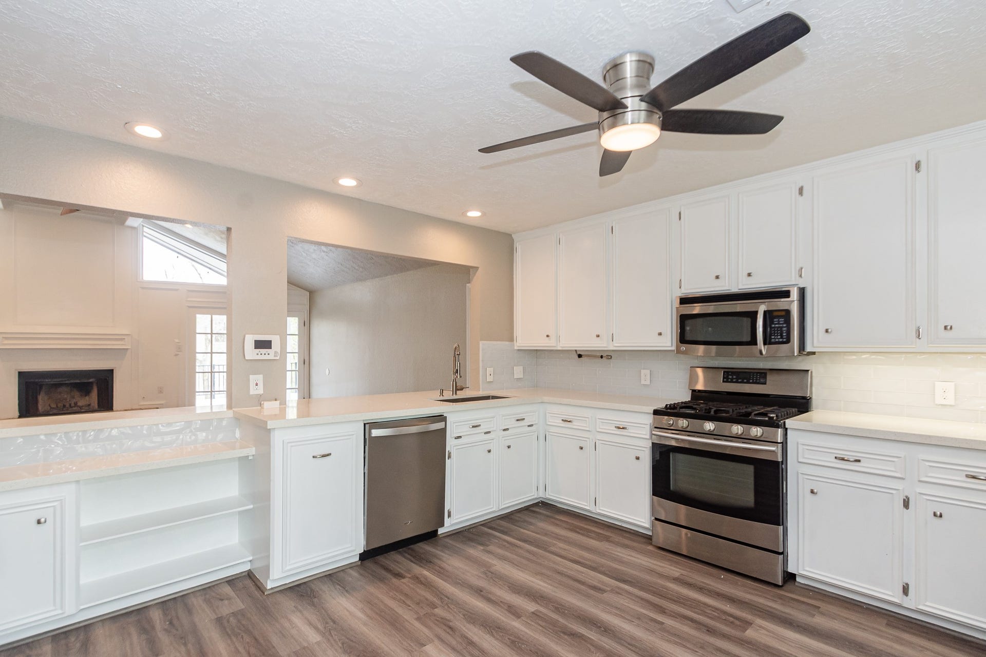 4509 Country Club Drive, Dickinson, TX 77539 White quartz countertops are paired with a deep single-basin sink and a sleek pull-down faucet. Under cabinet lighting.