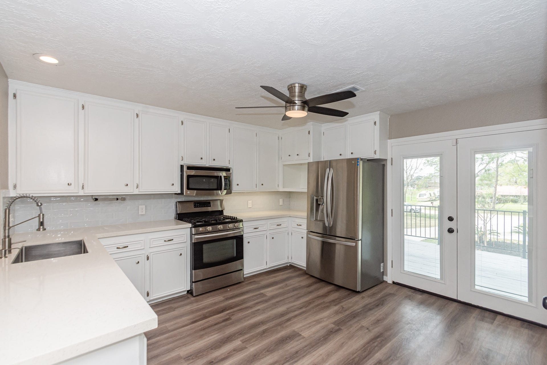 4509 Country Club Drive, Dickinson, TX 77539 This kitchen opens beautifully to the outdoors with double French doors leading directly to the 2nd-story deck. The stainless-steel refrigerator is included.