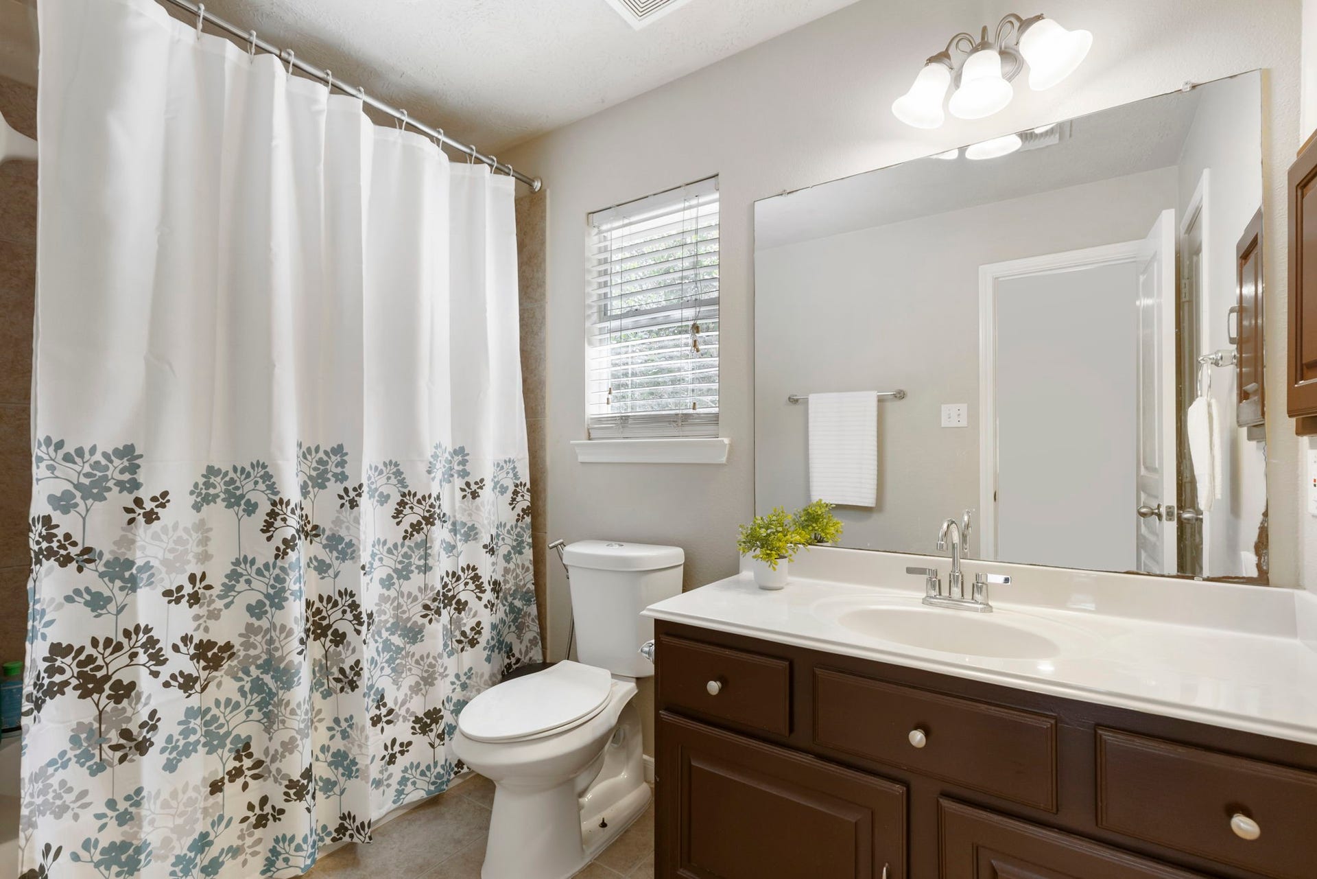 14 N Bardsbrook Circle, The Woodlands, TX 77382 The upstairs secondary bathroom features an extended vanity with ample counter space, great storage, and a bright, functional layout designed for everyday convenience.
