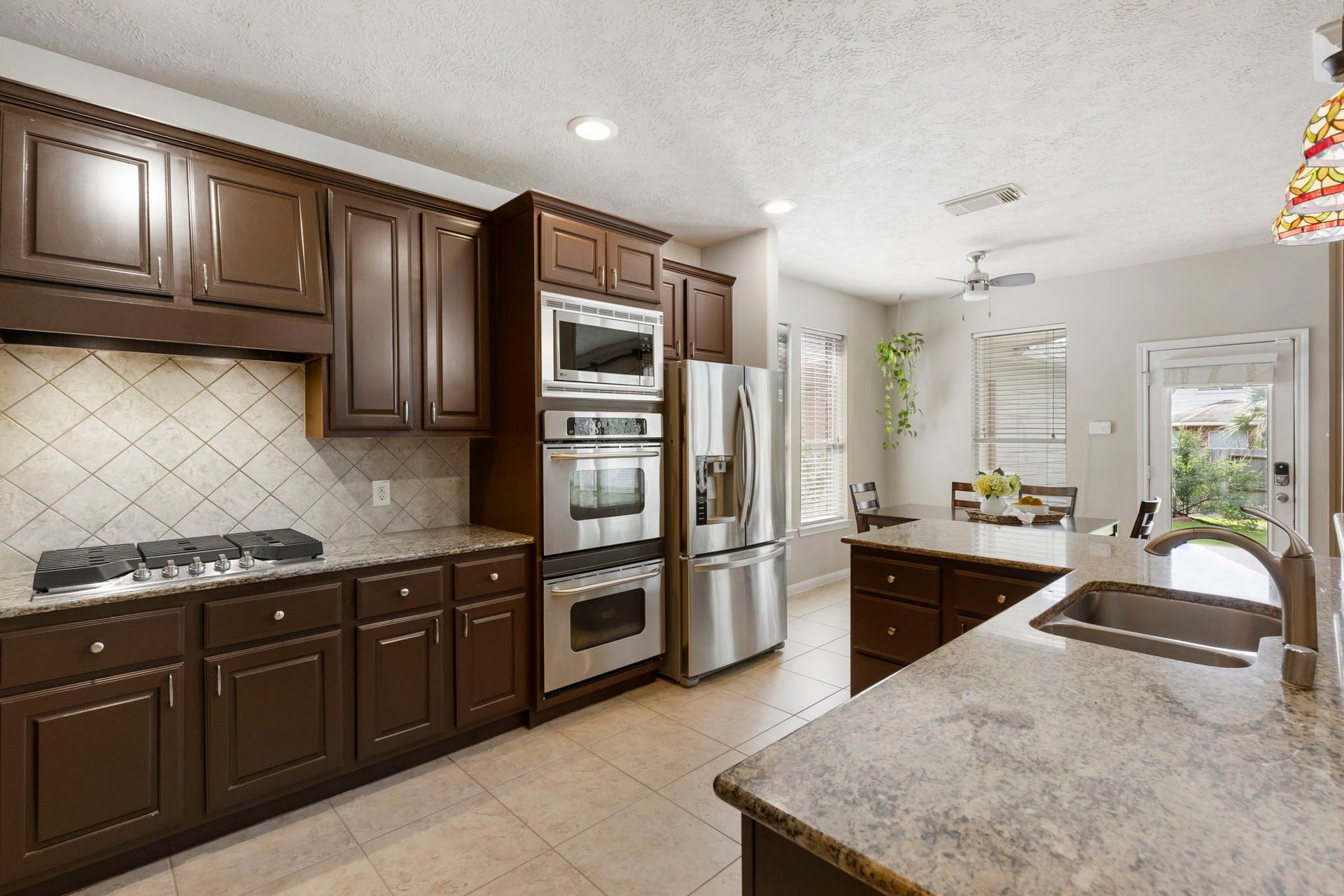 14 N Bardsbrook Circle, The Woodlands, TX 77382 Rich cabinetry, granite countertops, and upgraded appliances come together to create a kitchen that is both stylish and practical.