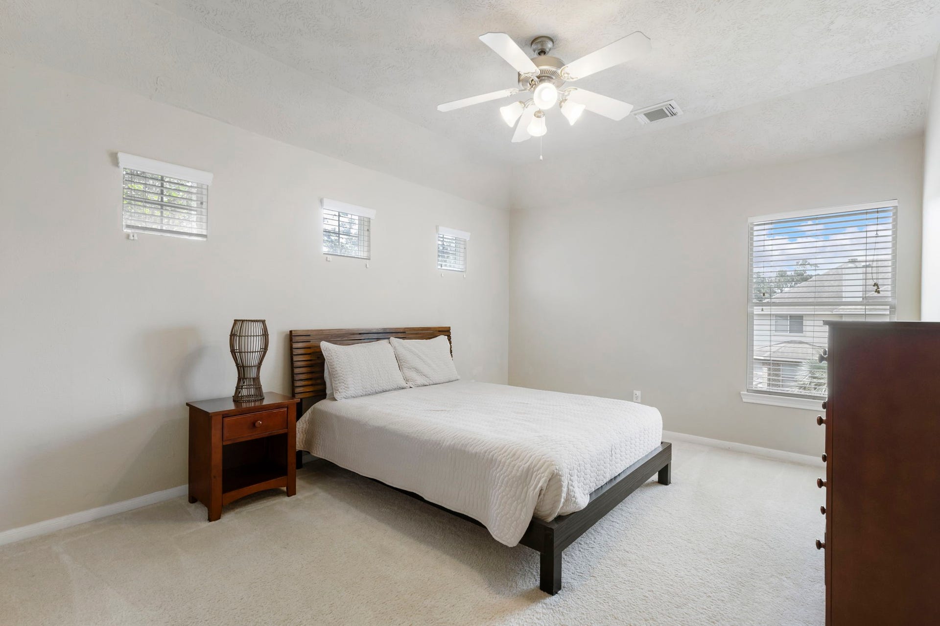 14 N Bardsbrook Circle, The Woodlands, TX 77382 This generously sized secondary bedroom features soaring ceilings, a ceiling fan, and multiple windows that create a bright, open, and airy feel throughout the room.
