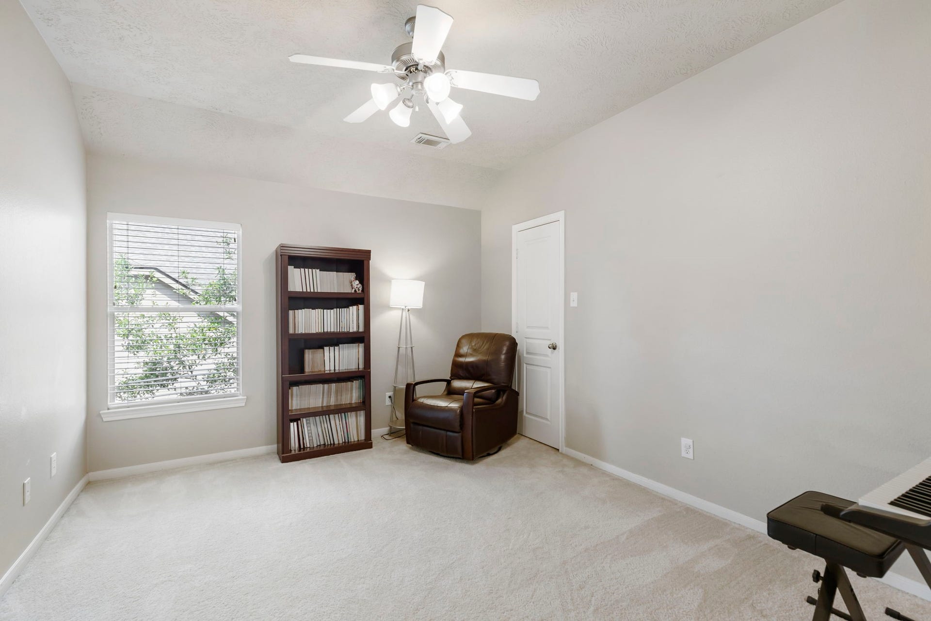 14 N Bardsbrook Circle, The Woodlands, TX 77382 This spacious secondary bedroom features a ceiling fan, large window that fills the room with natural light, and plenty of space to serve as a comfortable bedroom, private office, or creative space.