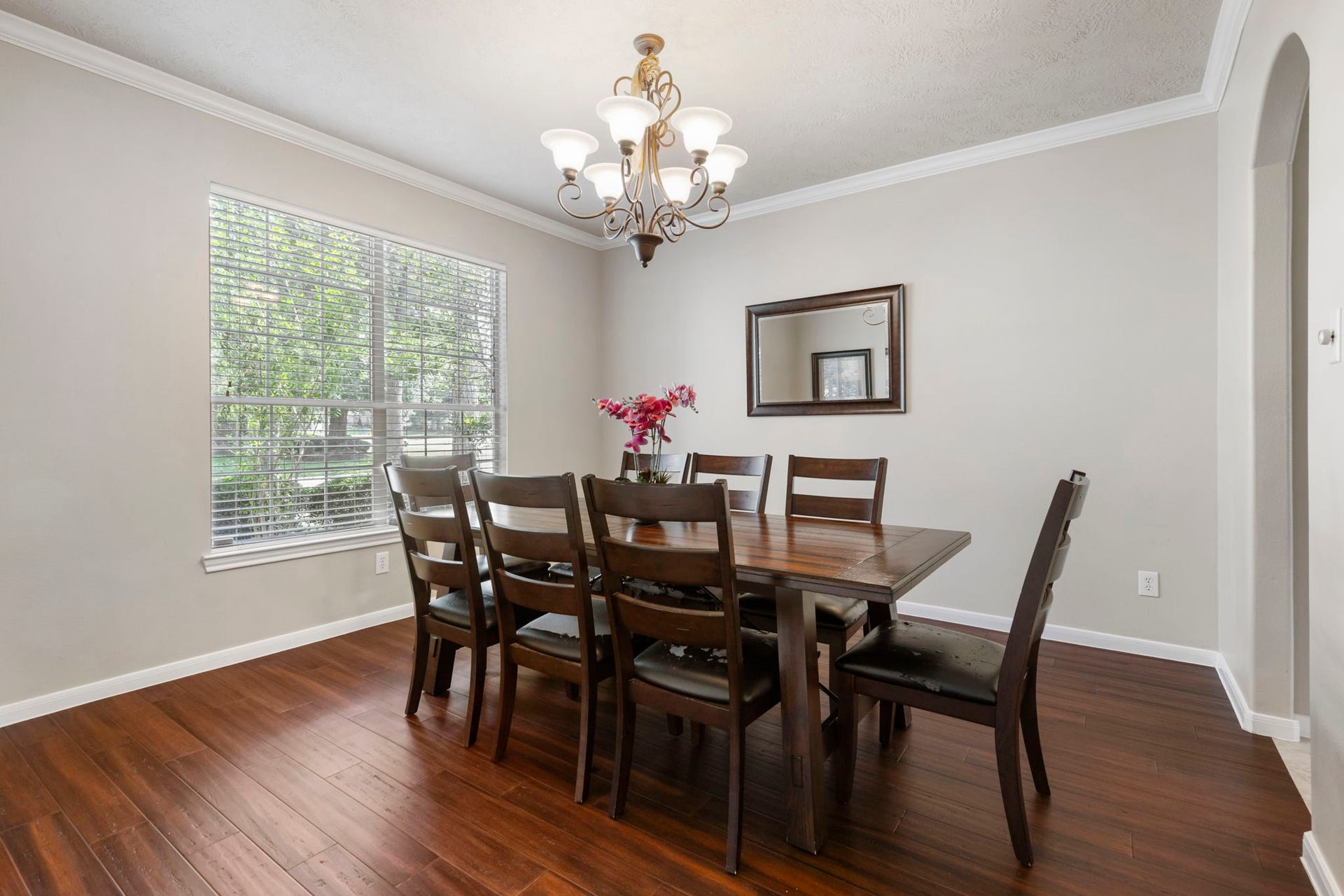 14 N Bardsbrook Circle, The Woodlands, TX 77382 Natural light fills the spacious dining room, featuring beautiful wood flooring, crown molding, and plenty of room to gather around the table