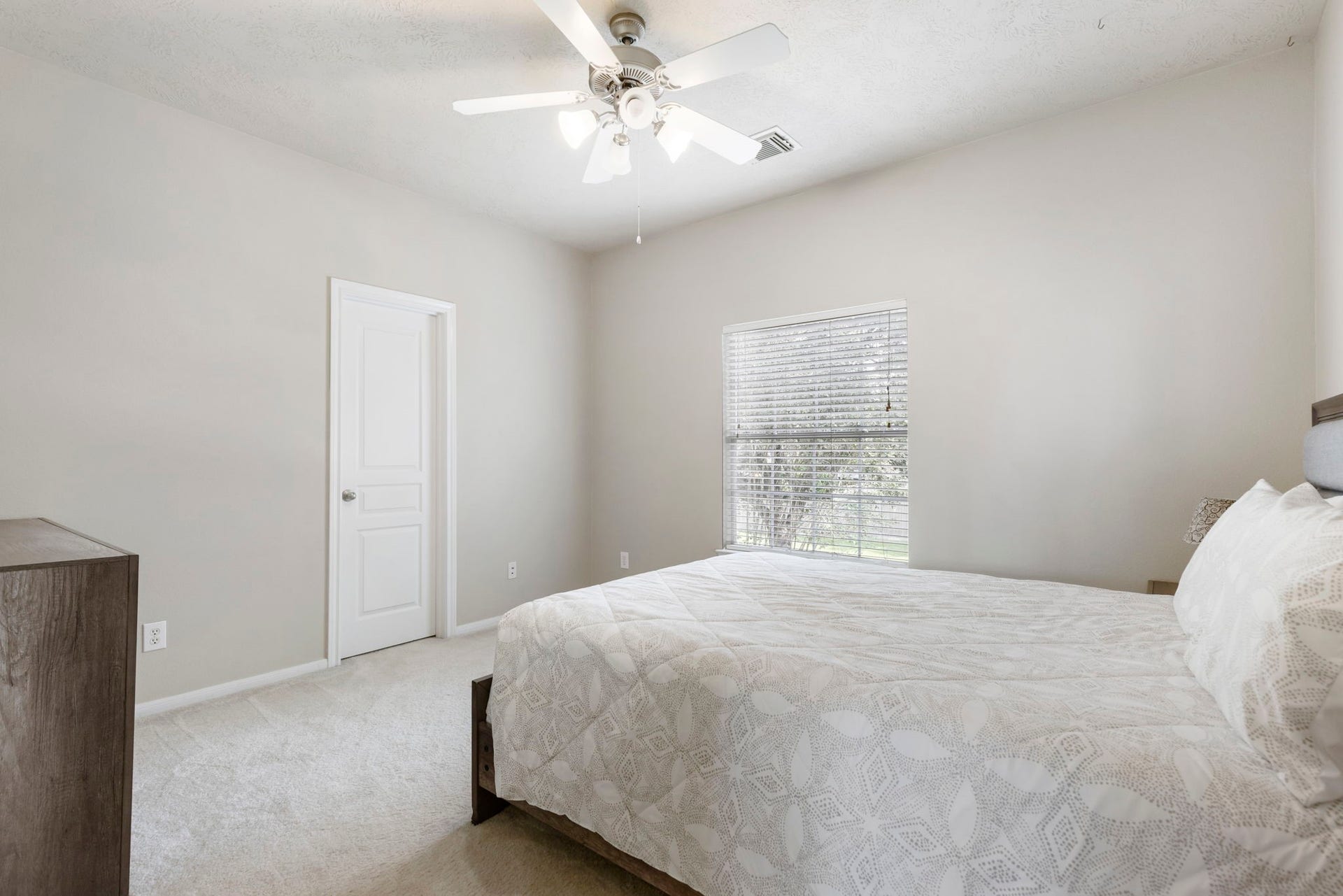 14 N Bardsbrook Circle, The Woodlands, TX 77382 This inviting secondary bedroom offers a comfortable layout with a ceiling fan, neutral finishes, and a large window overlooking the backyard.