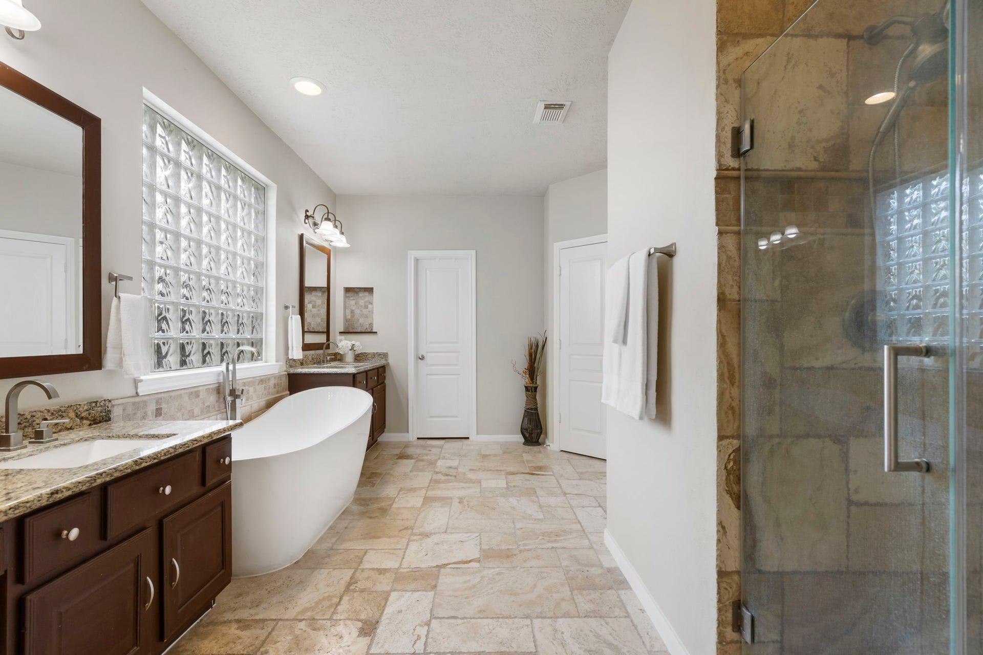 14 N Bardsbrook Circle, The Woodlands, TX 77382 A serene primary bath retreat featuring a freestanding soaking tub, spacious layout, natural light, and elegant finishes designed for relaxation.