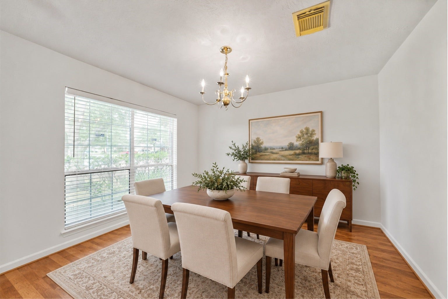 5614 Gaffney Lane, Houston, TX 77084 Virtually staged: Beneath the chandelier, the formal dining room is reimagined as an inviting place to gather, pairing warm wood flooring with a table for six, tailored seating, and a sunlit front window.