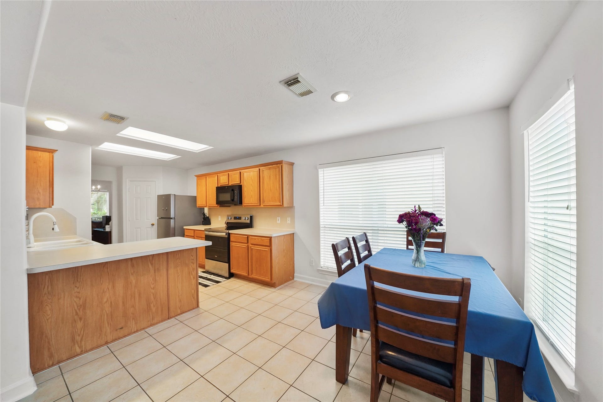 5614 Gaffney Lane, Houston, TX 77084 The breakfast area sits just off the kitchen, creating a cheerful spot for daily meals with a bright windowed backdrop.