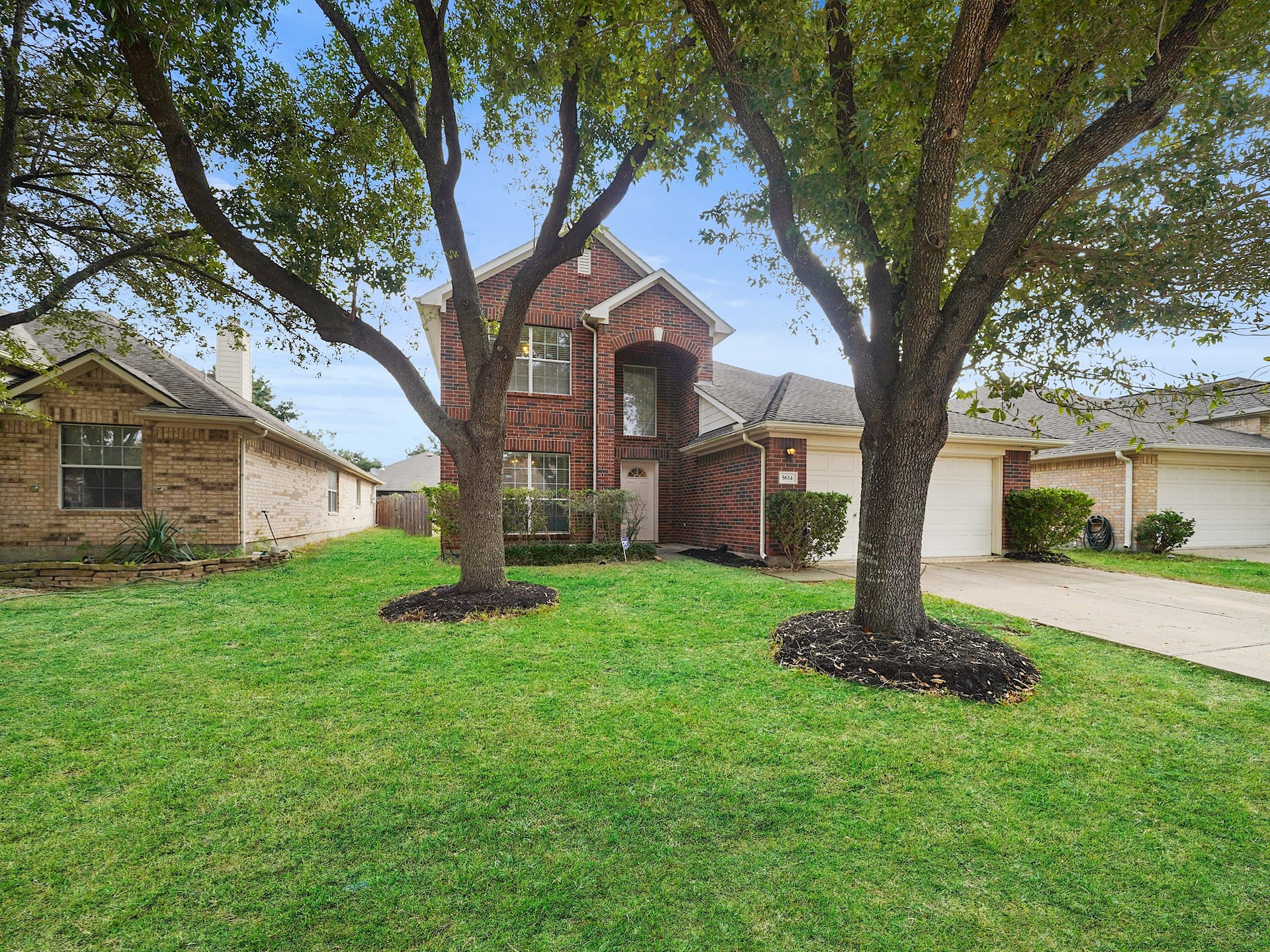 5614 Gaffney Lane, Houston, TX 77084 Set beneath mature shade trees, the brick faade and wide driveway create a warm first impression, with the two-car garage tucked neatly beside the covered entry.