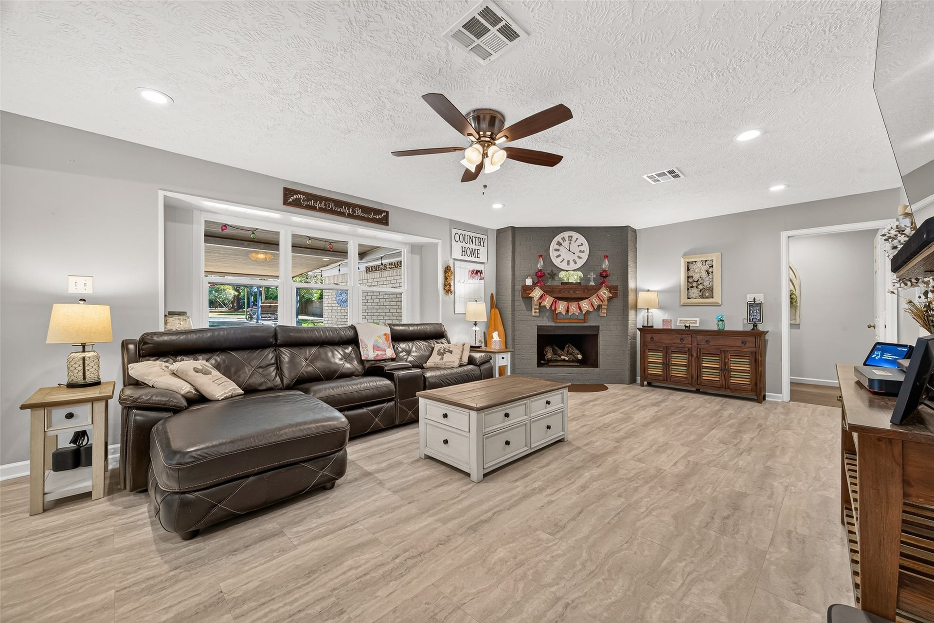 1535 Memorial Drive, Conroe, TX 77304 VERY SPACIOUS LIVING ROOM WITH LOTS OF NATURAL LIGHT, WOOD OR GAS BURNING FIREPLACE; VINYL FLOOR; THE DOOR TO YOUR FAR RIGHT LEADS TO ALL THE BEDROOMS AND GUEST BATHROOM.
