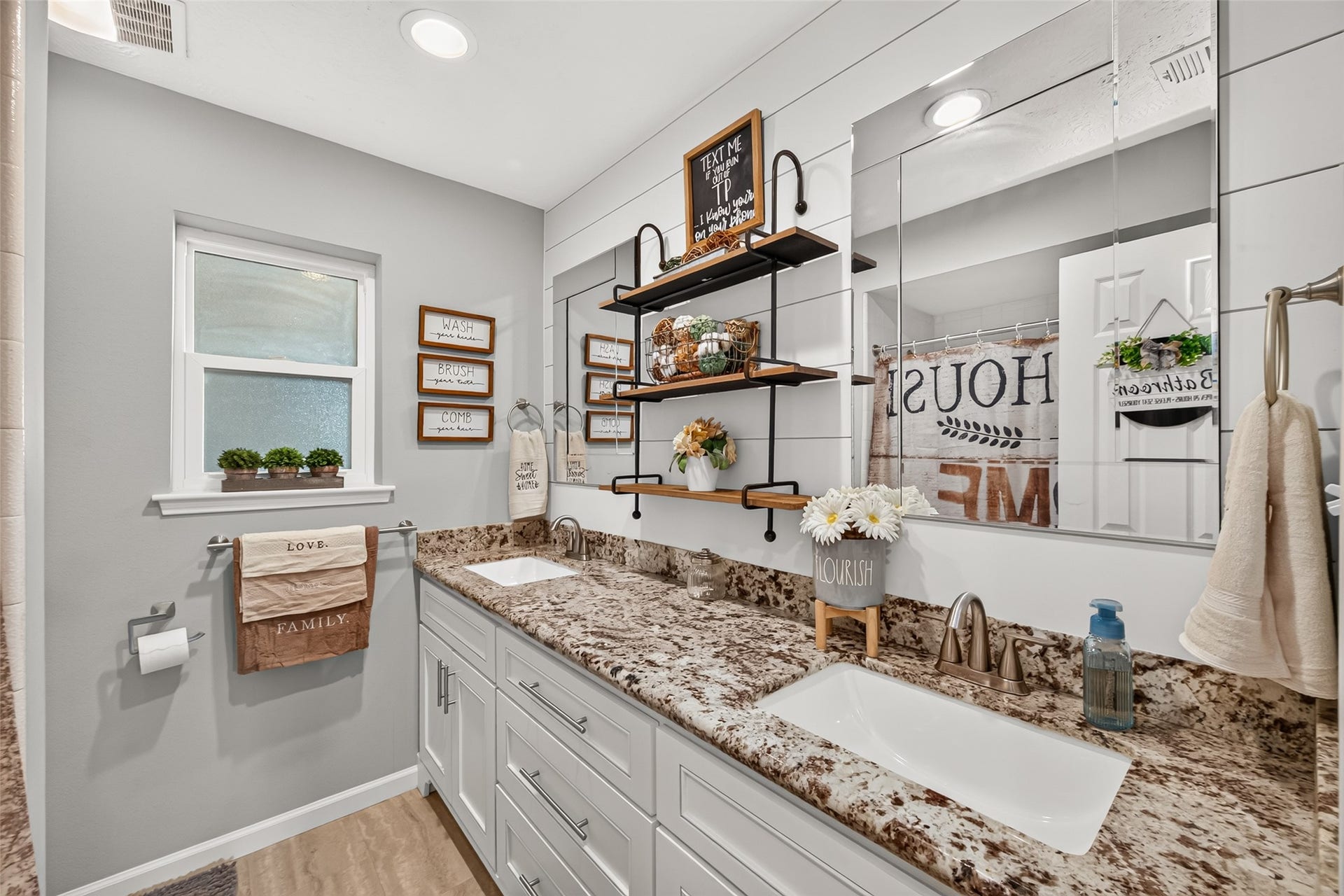 1535 Memorial Drive, Conroe, TX 77304 THE GUEST BATHROOM OFFERS A BEAUTIFUL GRANITE COUNTERTOP, DOUBLE SINKS, A TUB/SHOWER COMBO, CUSTOM SHELVES AND AN ABUNDANCE OF STORAGE.
