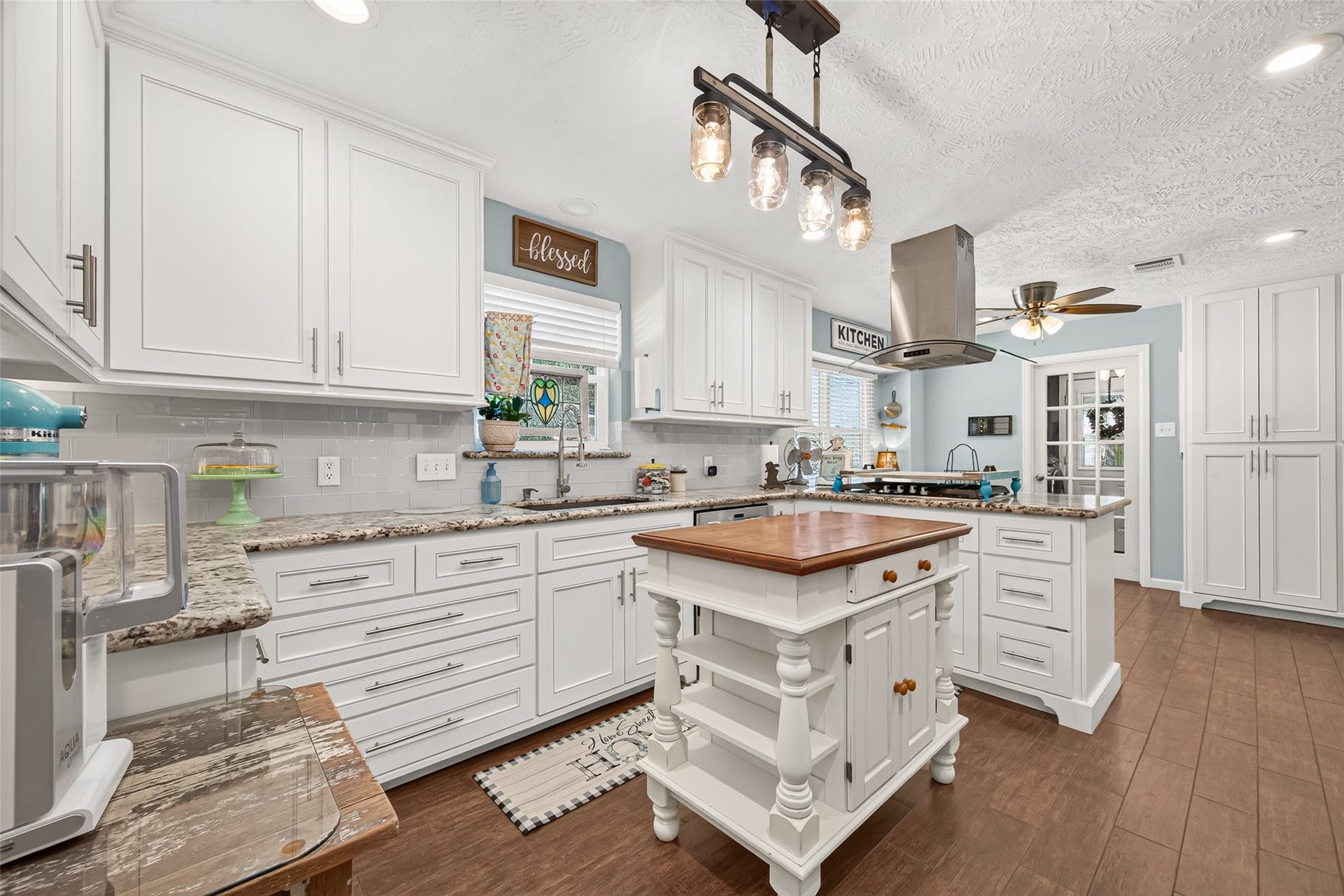 1535 Memorial Drive, Conroe, TX 77304 VIEW OF THE SPACIOUS KITCHEN, GRANITE COUNTERTOP, NEW KITCHEN FAUCET, BEAUTIFUL WOOD LOOKING TILE FLOORS, PANTRY TO FAR RIGHT WITH SLIDING OUT DRAWERS AND LOTS OF PANTRY SPACE.