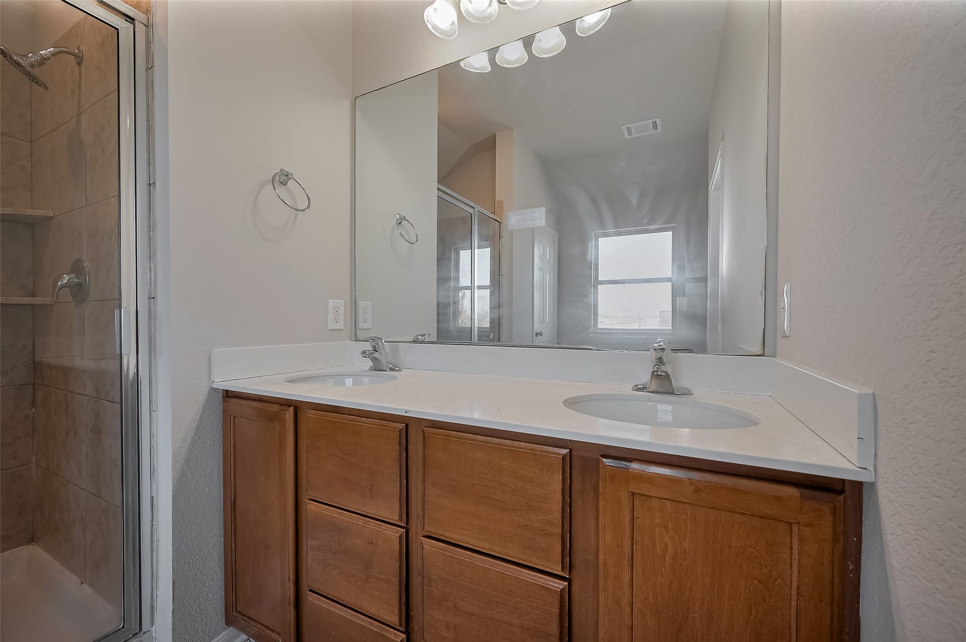 24114 Morrison Lane, Katy, TX 77493 Bathroom features a double vanity with a large mirror and wooden cabinets.