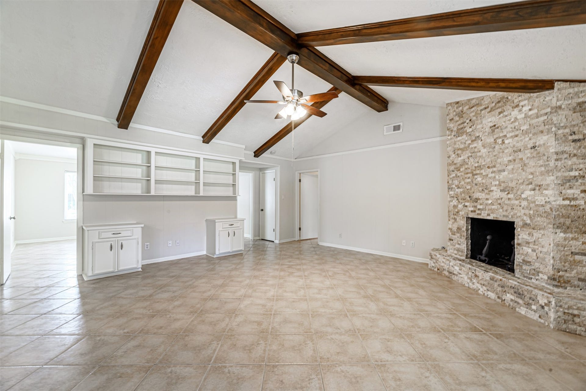 124 Dogwood Street, Sugar Land, TX 77478 The living room's stunning stone fireplace creates a cozy and inviting atmosphere, perfect for relaxation.