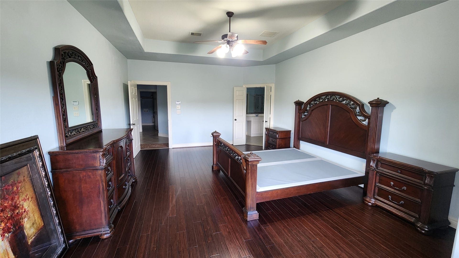 5442 Faircreek Ln Lane, Katy, TX 77450 Experience luxury in this spacious master bedroom, featuring elegant dark wood flooring and sophisticated furniture, perfect for ultimate relaxation.