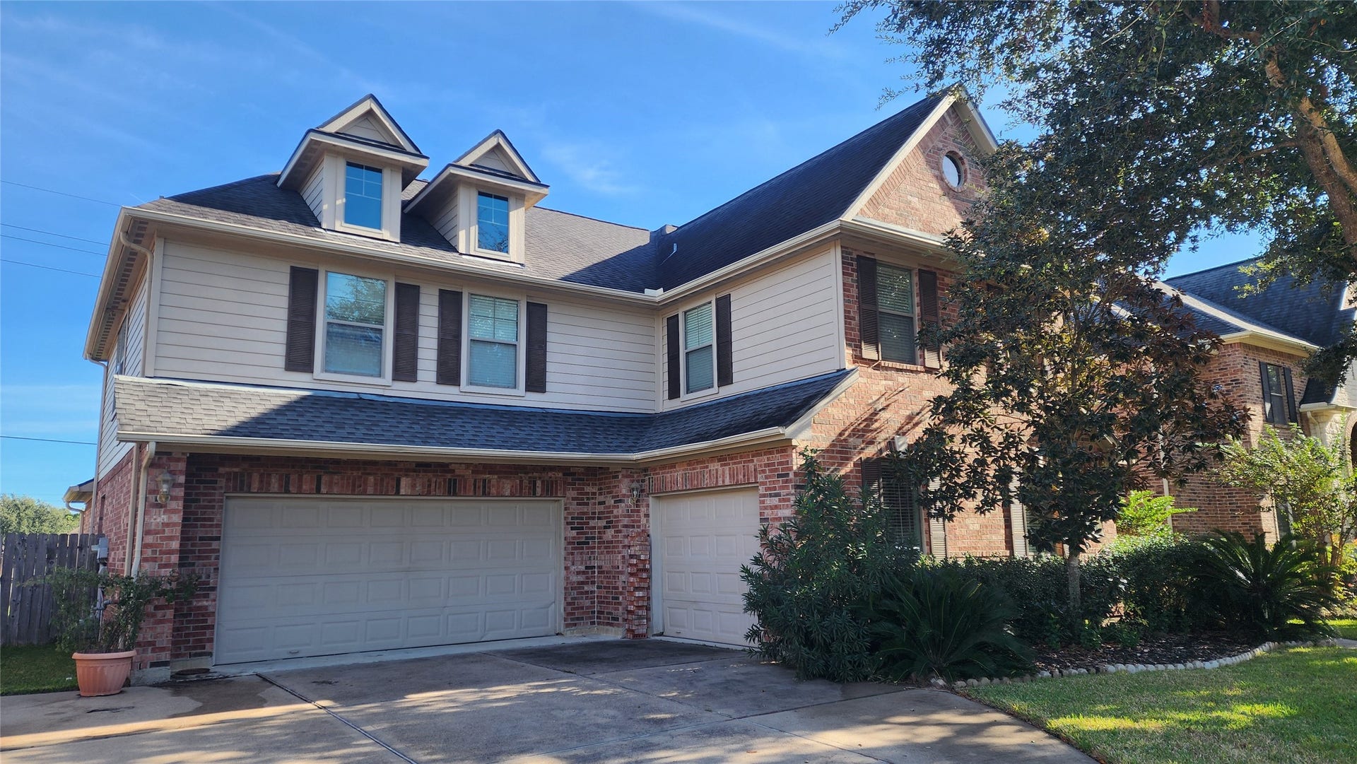 5442 Faircreek Ln Lane, Katy, TX 77450 Charming two-story brick home with lush landscaping, and classic dormer windows.