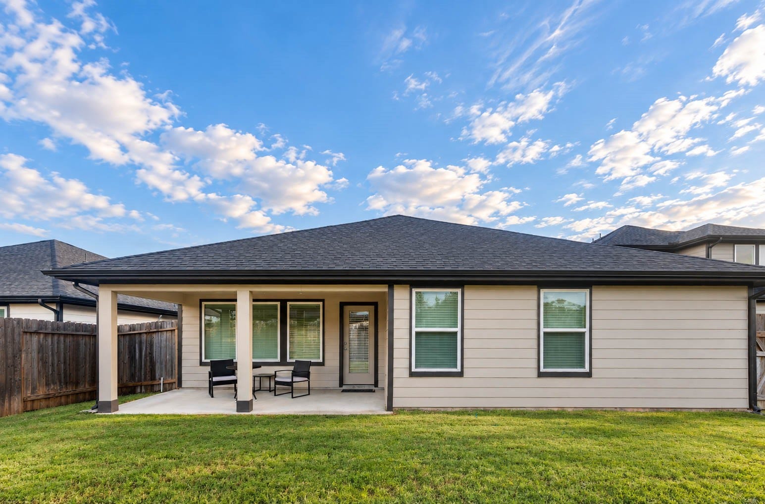 30502 White Cliff Court, Fulshear, TX 77441 Charming backyard with a covered patio, perfect for relaxing or entertaining, complemented by a well-maintained lawn.